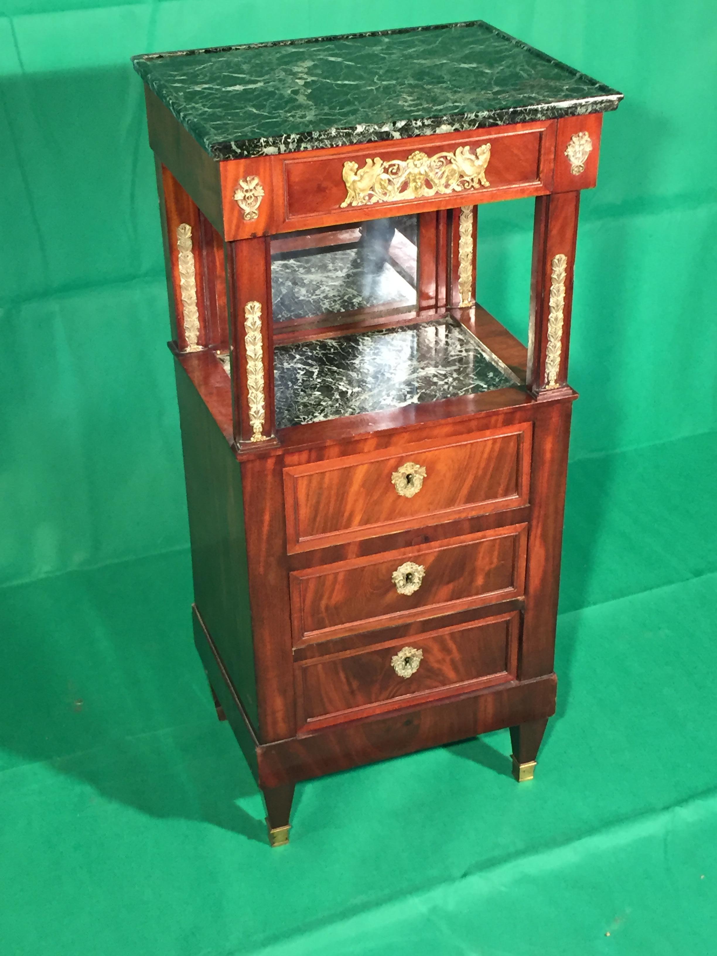 French man's toilet, in Empire style, Napoleon III era. Mahogany wood, marble sliding green alps. Concealed mirror with various adjustments, upper side drawer and three front drawers. In good condition, there are only two bronze back feet and the