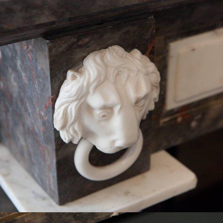 19th century unique Empire style brown Bois-Jourdan marble fireplace mantelpiece, with a white statuary Carrara hand carved Roman Rosette on the centre tableau; Flanked Either side by columns; Finley carved lion heads, circa 1815. This marble was