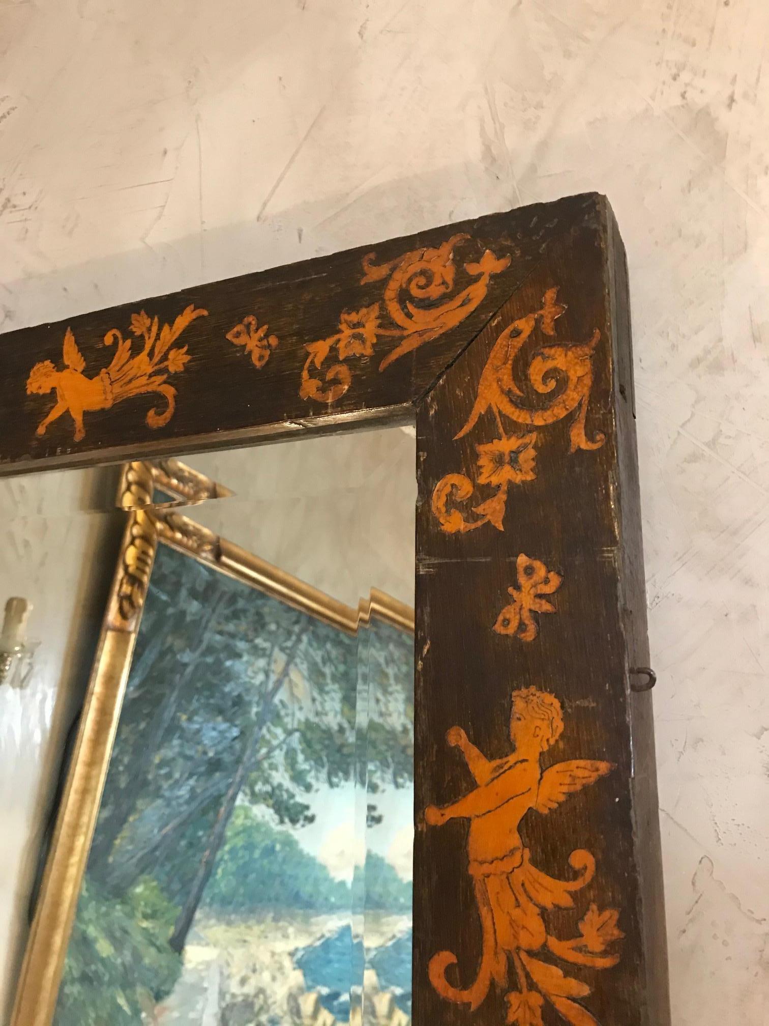 Beautiful and rare 19th century Empire period made with oak and beveled glass mirror from the 1883.
The oak frame is decorated with nice lions, angels and butterflies marquetry. 
The back is made with two different color of parquet and we can see