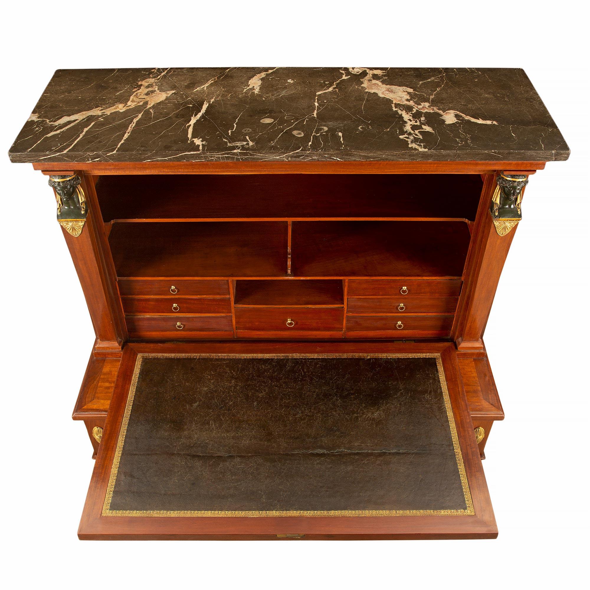 A most handsome Continental mid 19th century Empire st. mahogany, ormolu, patinated bronze and ebonized fruitwood drop front secretary. The secretary is raised by four square tapered legs ending with ebonized fruitwood claw feet over a octagon