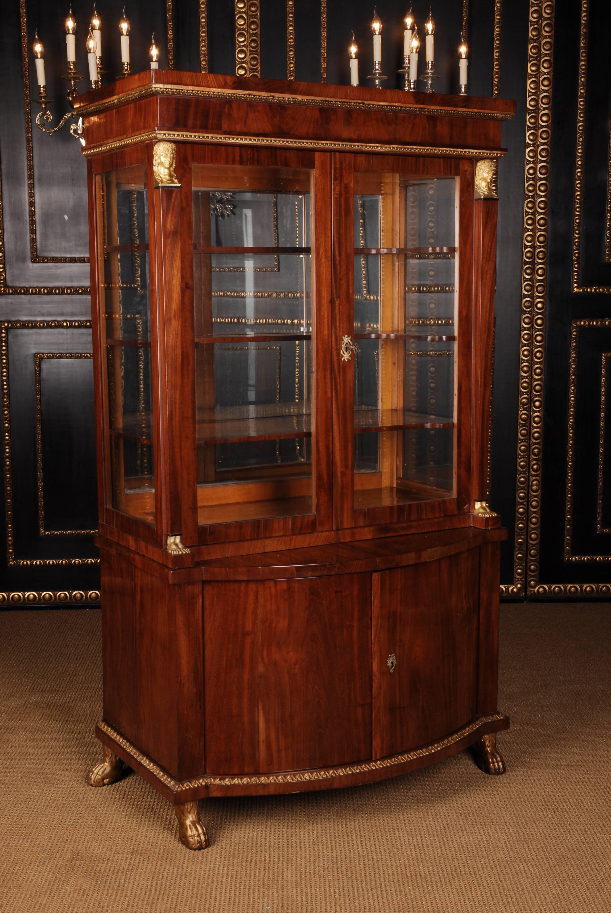 High-quality Cuba mahogany on solid softwood. Architecturally articulated body. Two-door, bent frame box on pressed, carved, poliementvergolddete claw feet. Recessed tower with two triple, sprout-glazed, castellated doors Flanked by slightly conical
