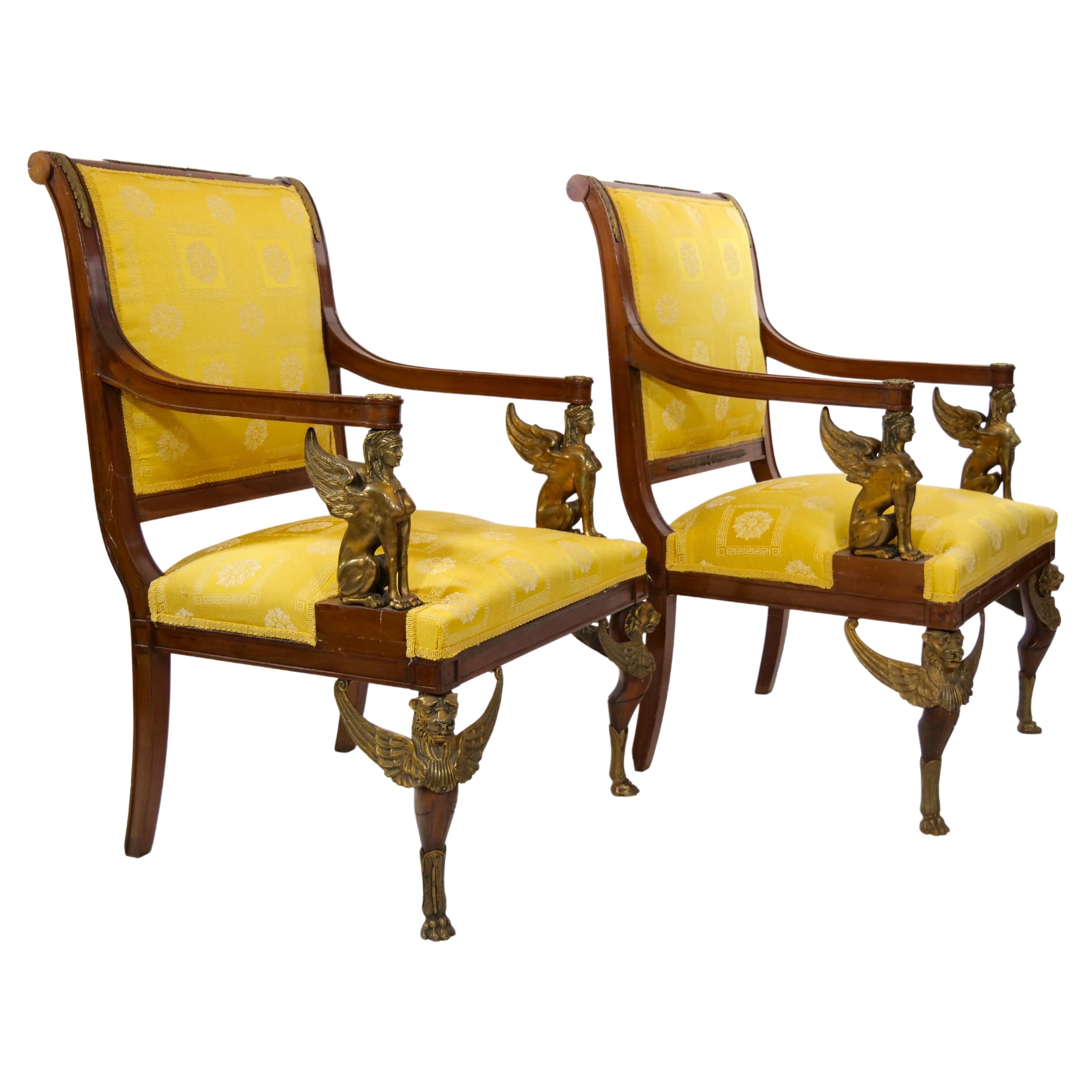 19th century French Empire style handcrafted gilt bronze mahogany framed upholstered pair of armchair. Each armchairs is set on four straight mahogany legs, the front two of which are set on gilt bronze paw feet. Gilt bronze sphinxes serve as arm