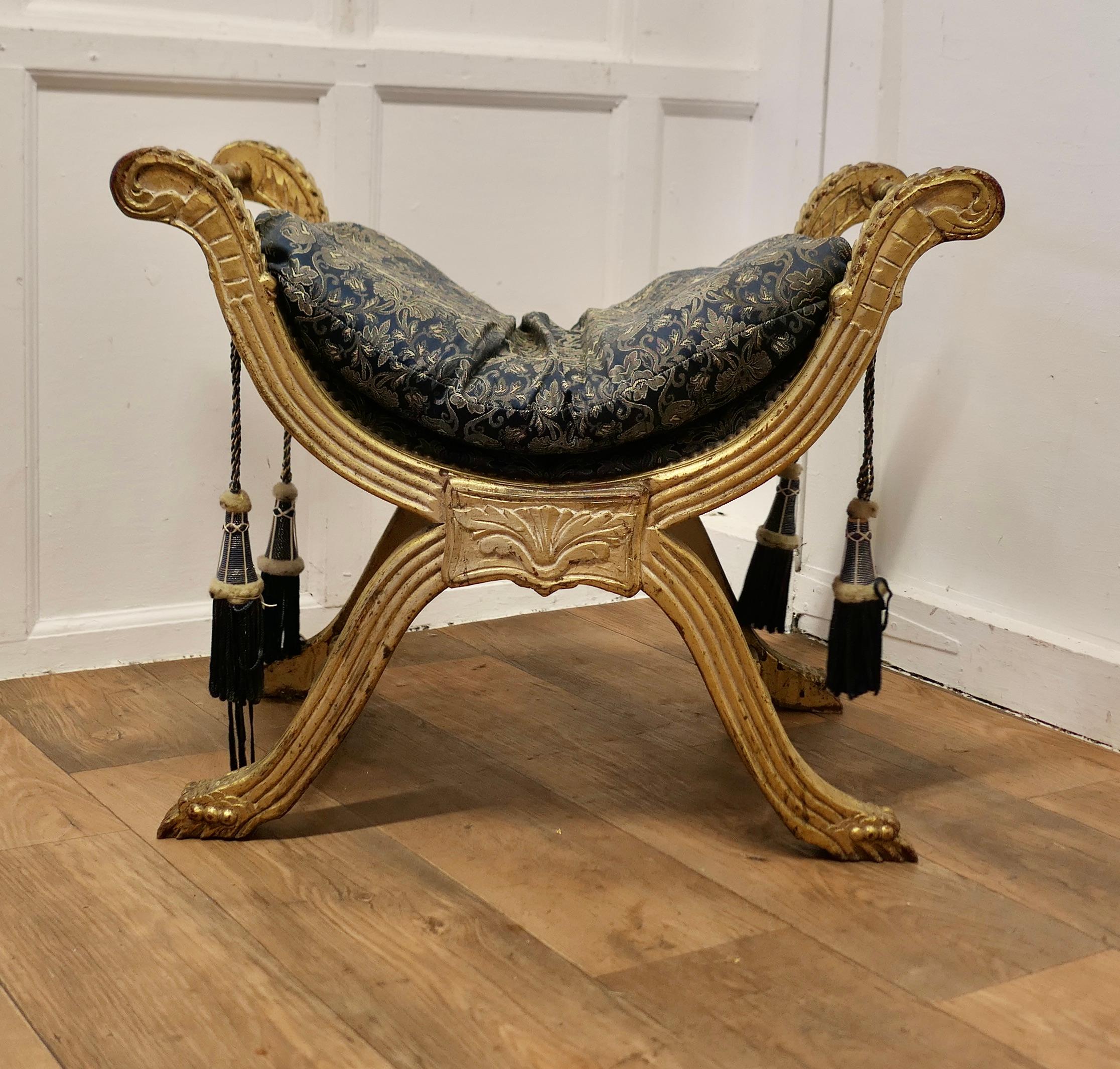 Tabouret de style Empire du 19ème siècle avec cadre en X doré 

Superbe pièce, ce tabouret antique néoclassique à cadre en X, est un objet de collection.  de style Empire, il est doté d'une assise tapissée de soie ancienne et d'un coussin assorti et