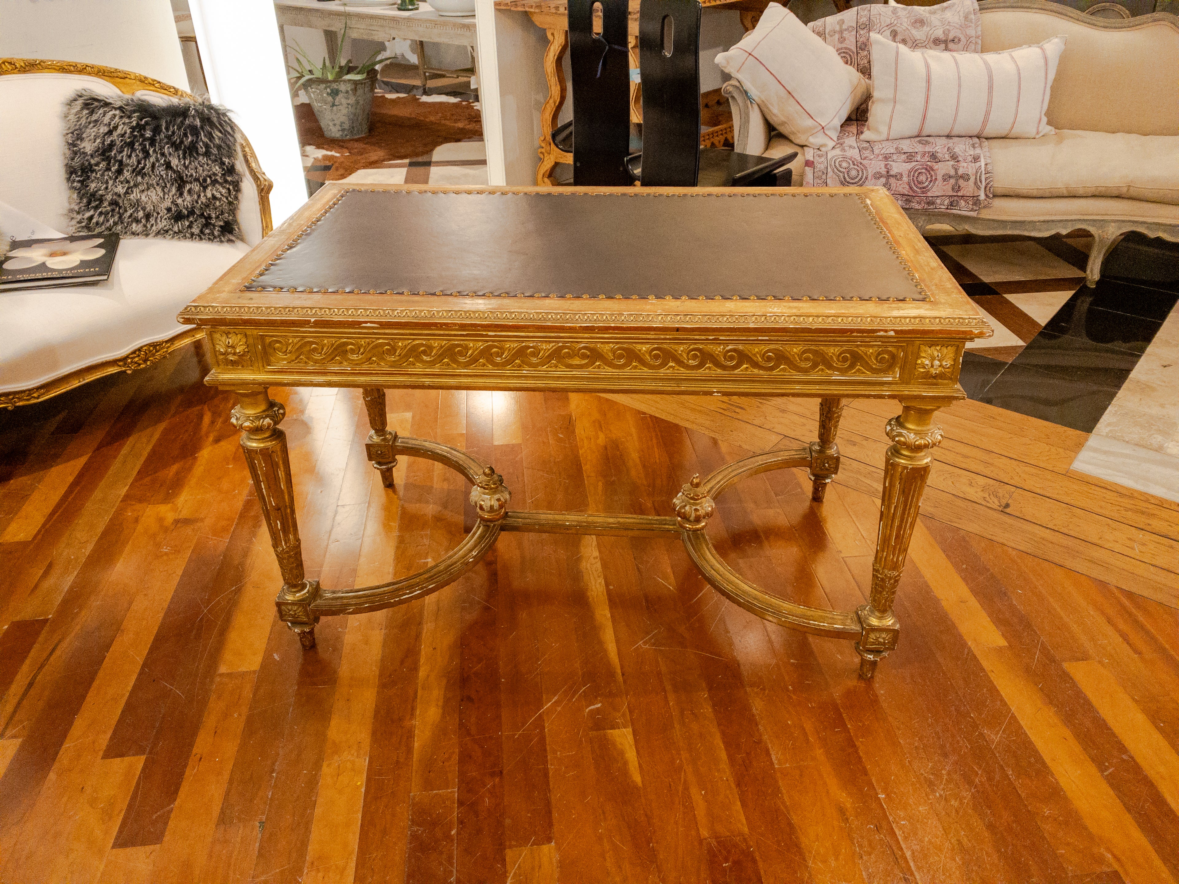 This 19th Century Empire Style Gold Leaf Library Table/Desk is a truly exquisite piece of furniture that exudes timeless elegance and sophistication. Crafted in the opulent Empire style, it showcases the grandeur and luxury associated with this