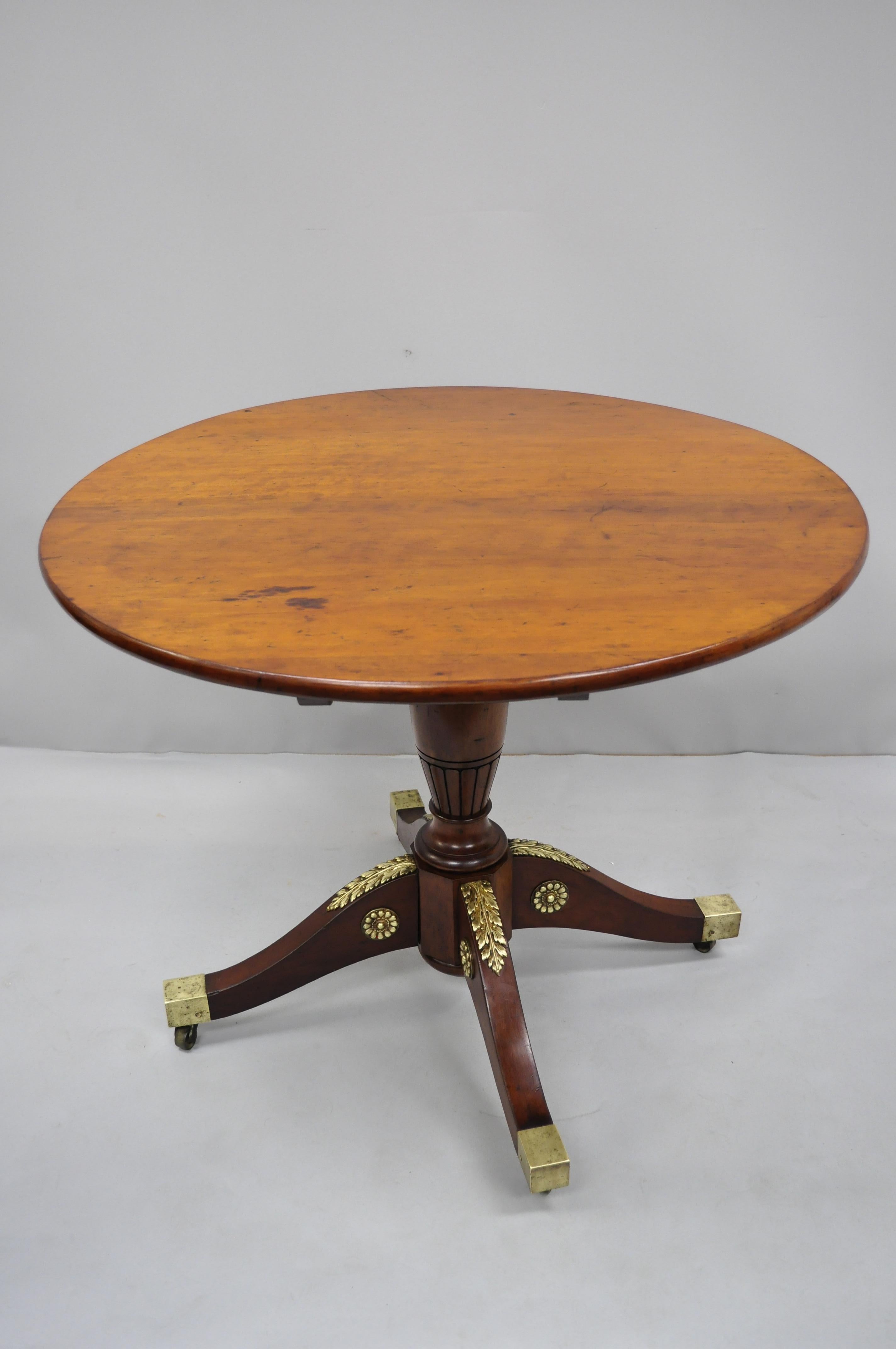 19th century, French Empire style Round mahogany tilt-top table with bronze ormolu. Item features ornate cast bronze ormolu, brass casters, carved central column, beautiful wood grain, very nice antique item, quality craftsmanship, circa 19th