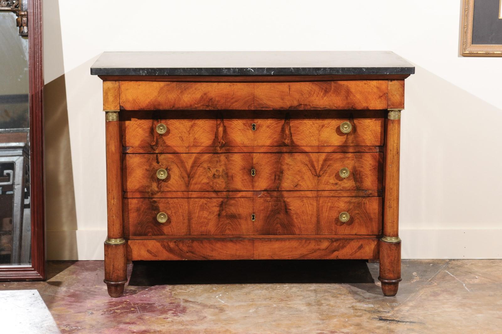 A beautiful Empire chest of bookmatched burled walnut...wonderful patina. The top drawer is hidden in that it has no hardware. Below are three drawers with bronze hardware. ormolu-mounted columns are on both sides supported by bun feet on the front.