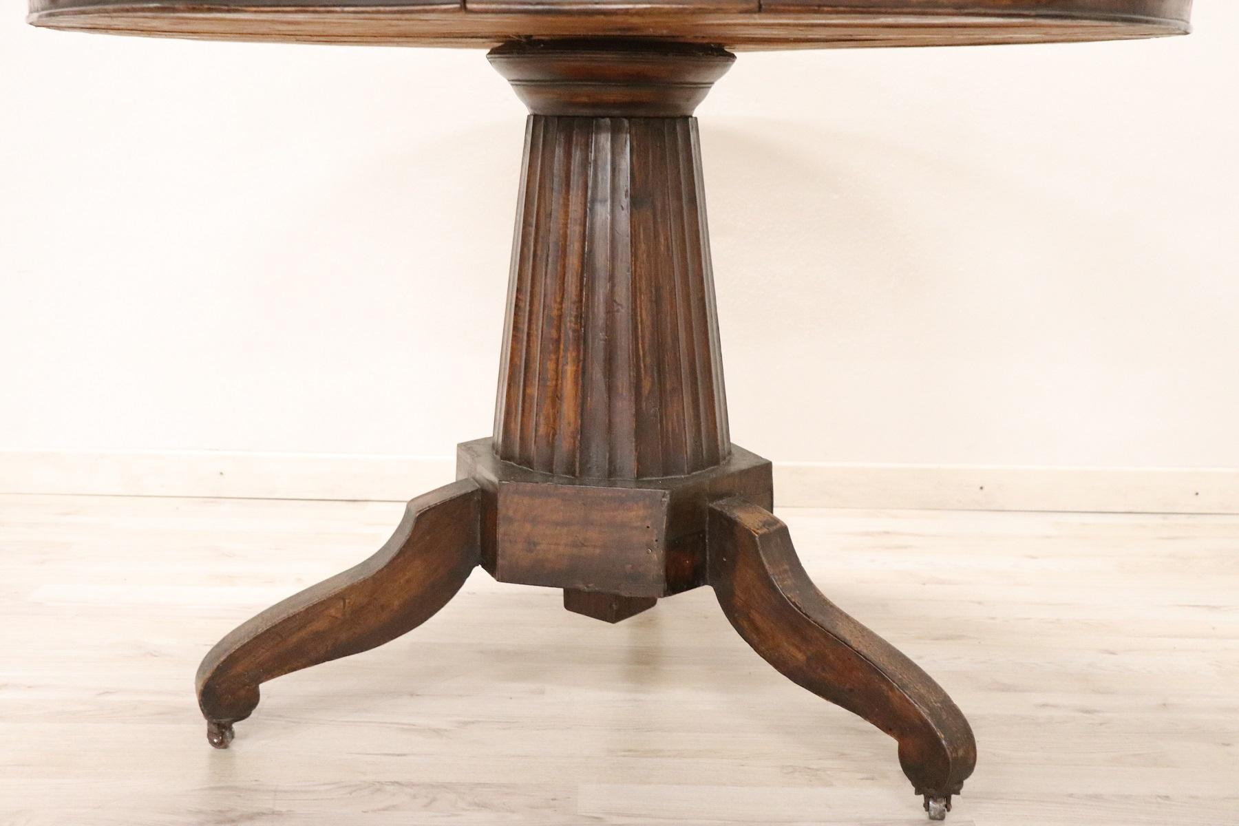 Beautiful important French Empire 1804s-1815 19th century in solid walnut. Table with elegant turned central leg made from a single wooden block and delicate feet. Particular and practical drawer. The feet end with small brass wheels that were often