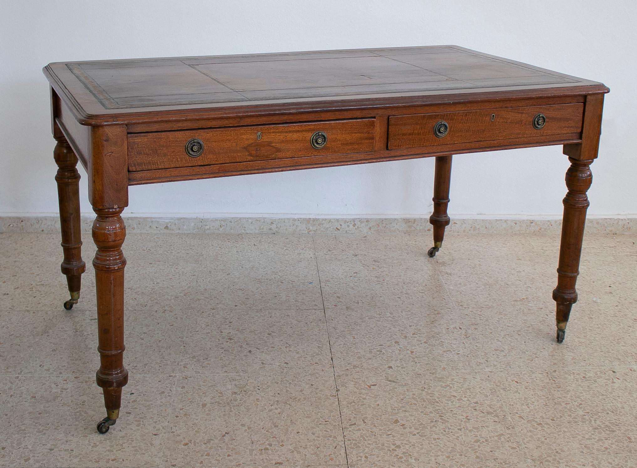 Antique 19th century English 2-drawer leather top bureau desk with bronze wheels.