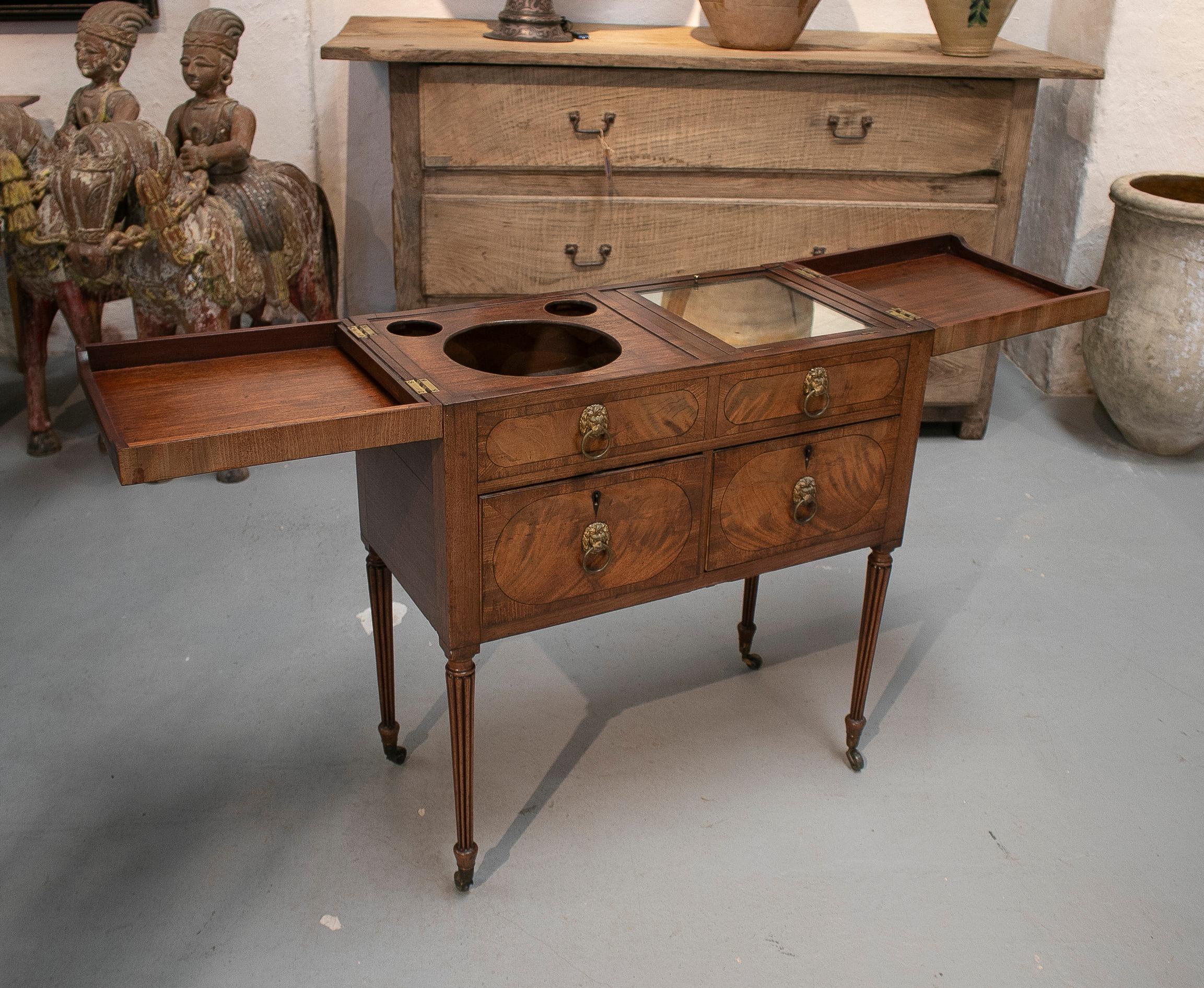 Antique 19th century English 4-drawer mahogany veneered mirrored dressing table with wash basin and bronze wheels.