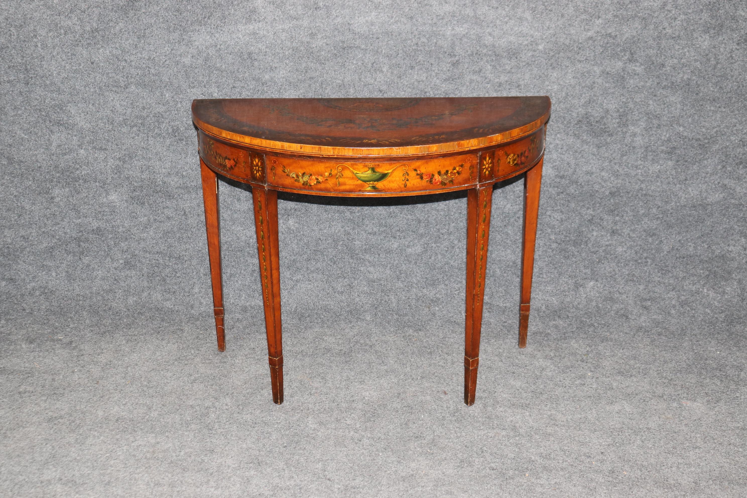 This is a fantastic paint decorated English-made Adams style satinwood game table with a masterfully painted scene of frolicking cherubs and floral scenery everywhere else. teh patina of the piece is beautiful and in good condition. The leather top