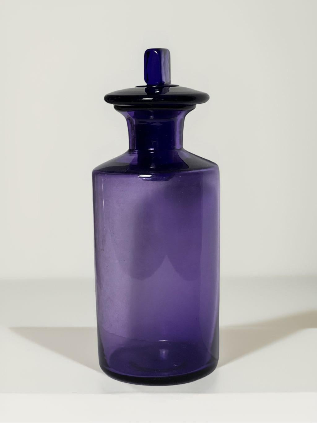 Antico vaso da farmacista inglese del XIX secolo, soffiato a mano e di colore viola ametista, con tappo originale. Il corpo è rotondo, il collo angolare e il tappo è quadrato. Colore bello, profondo e chiaro. Adorabile su una vanità, una libreria,