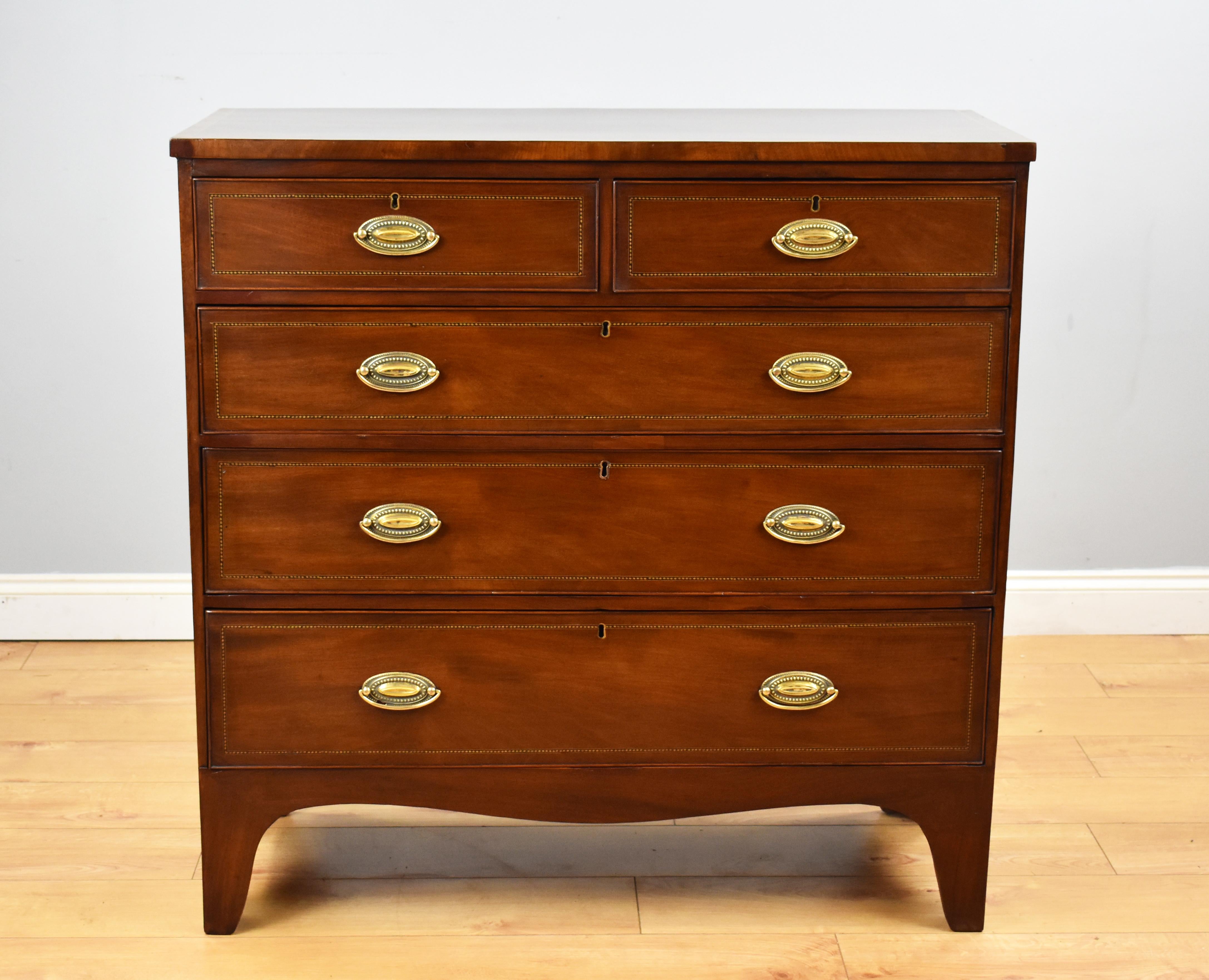 For sale is an antique mahogany inlaid chest of drawers, having an inlaid and cross banded top above an arrangement of five graduated drawers. The chest remains in good condition for its age. 

Measures: Width: 41.25
