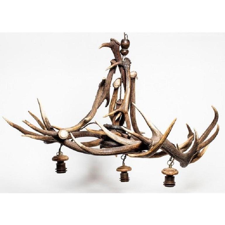 Wonderful antique antler three-light chandelier, made in England circa 1870. This rustic chandelier caught our eye at our favorite antique fair in England. Recently rewired for modern use with silk-wrapped cord. Excellent condition.

