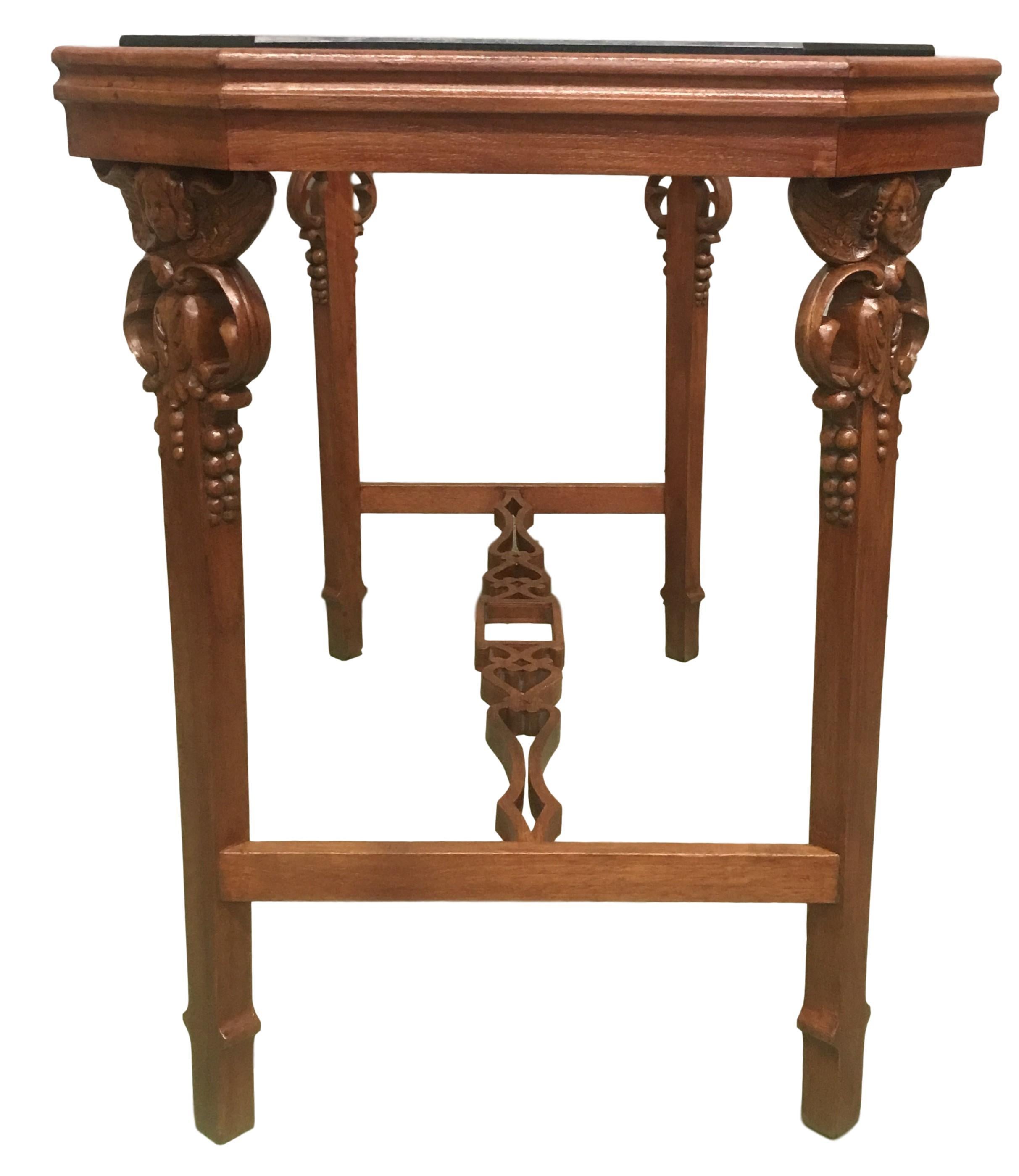 Englischer vierbeiniger Tisch aus der Jahrhundertwende mit einer schrägen Eckplatte und geschnitzten Cherubinen in den vier Beinen.