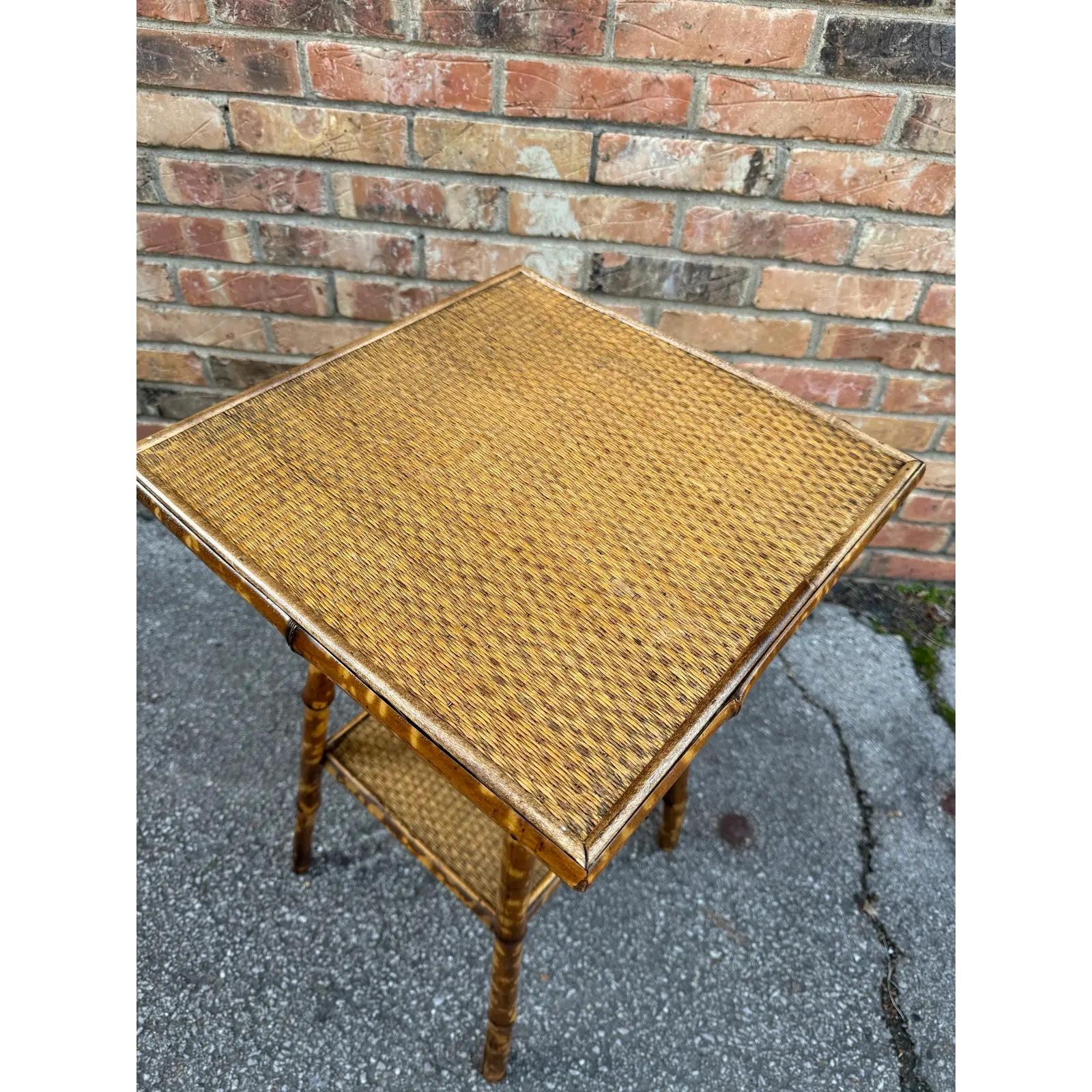 This is a beautiful 19th century English bamboo side table! Tables like these make excellent accent pieces because their color and style is so versatile. The dark hues of the burnt bamboo pair perfectly with the lighter golden of the rattan top and
