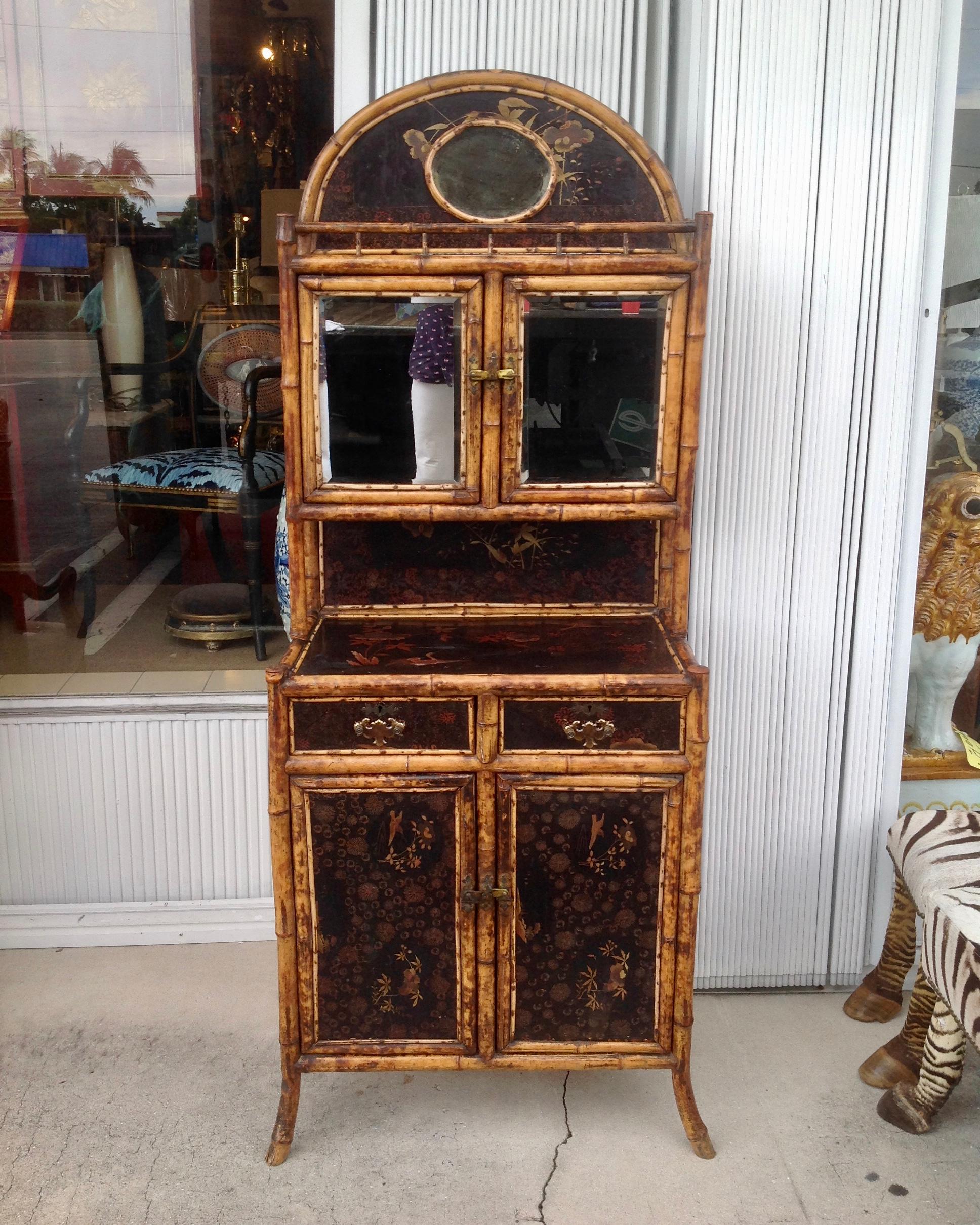 Elegant design fashioned with mirrored doors and accented with a central
mirrored medallion. The cabinet is accented with chinoiserie lacquered panels.
Unusual form and design from Edwardian era.