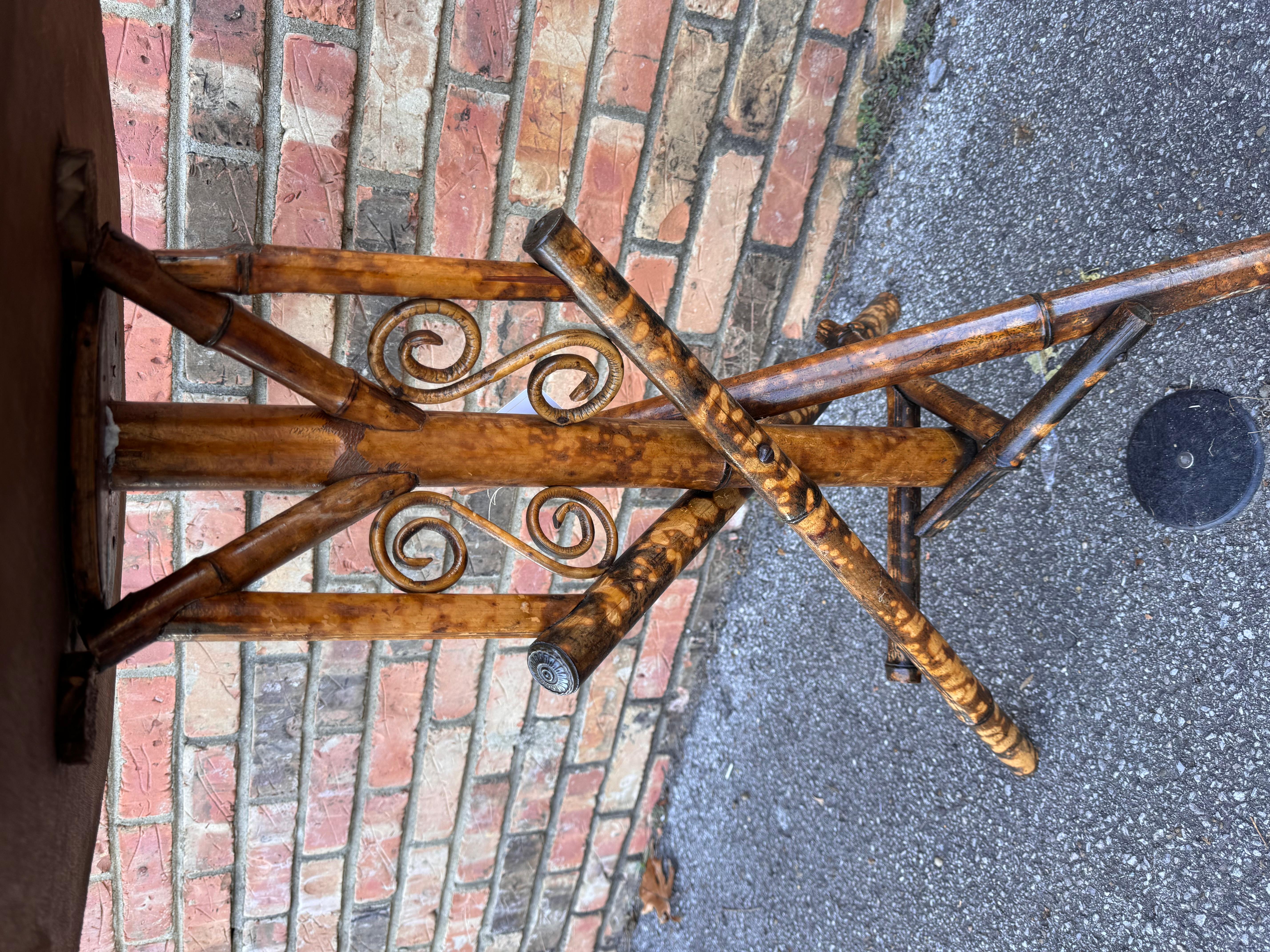 Quel design inhabituel que cette table d'appoint en bambou anglais du XIXe siècle ! Les tables de ce type constituent d'excellentes pièces d'accent, car leur couleur et leur style sont très polyvalents. Les teintes sombres du bambou brûlé se marient