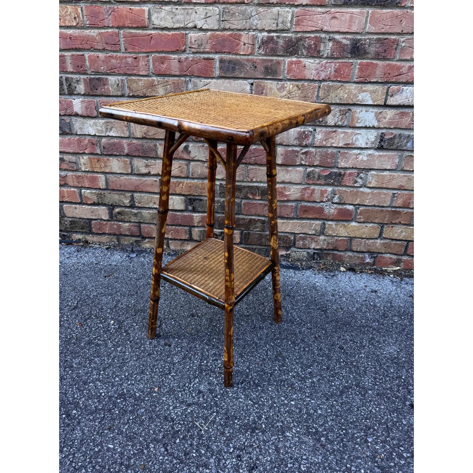 This is a beautiful 19th century English bamboo side table! Tables like these make excellent accent pieces because their color and style is so versatile. The dark hues of the burnt bamboo pair perfectly with the lighter golden of the rattan top and