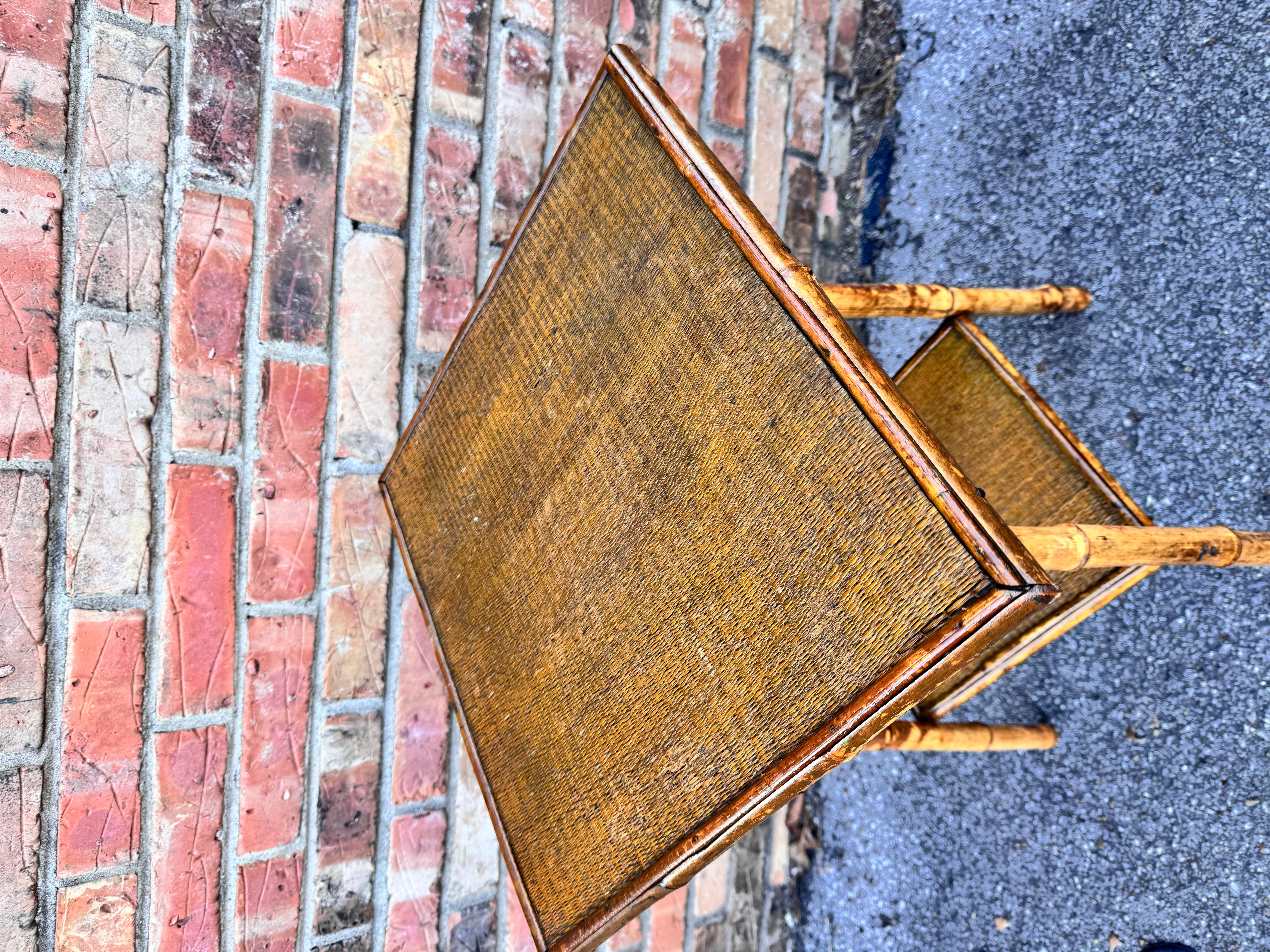 This is a beautiful 19th century English bamboo side table! Tables like these make excellent accent pieces because their color and style is so versatile. The dark hues of the burnt bamboo pair perfectly with the lighter golden of the rattan top and