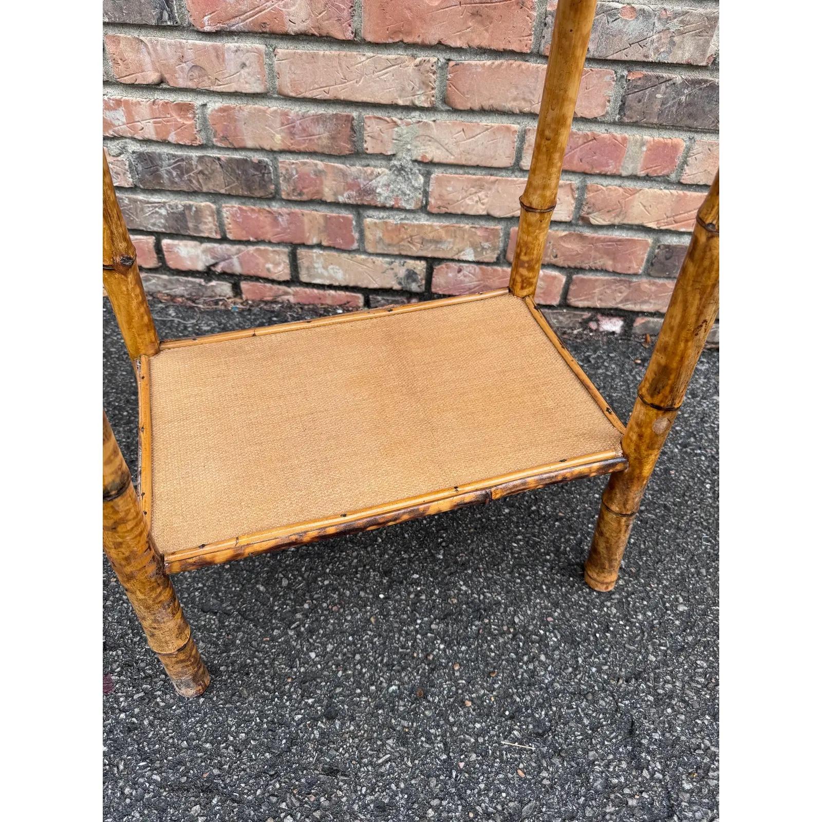 This is a beautiful 19th century English bamboo side table! Tables like these make excellent accent pieces because their color and style is so versatile. The warm hues of the burnt bamboo pair perfectly with the lighter golden of the rattan top and
