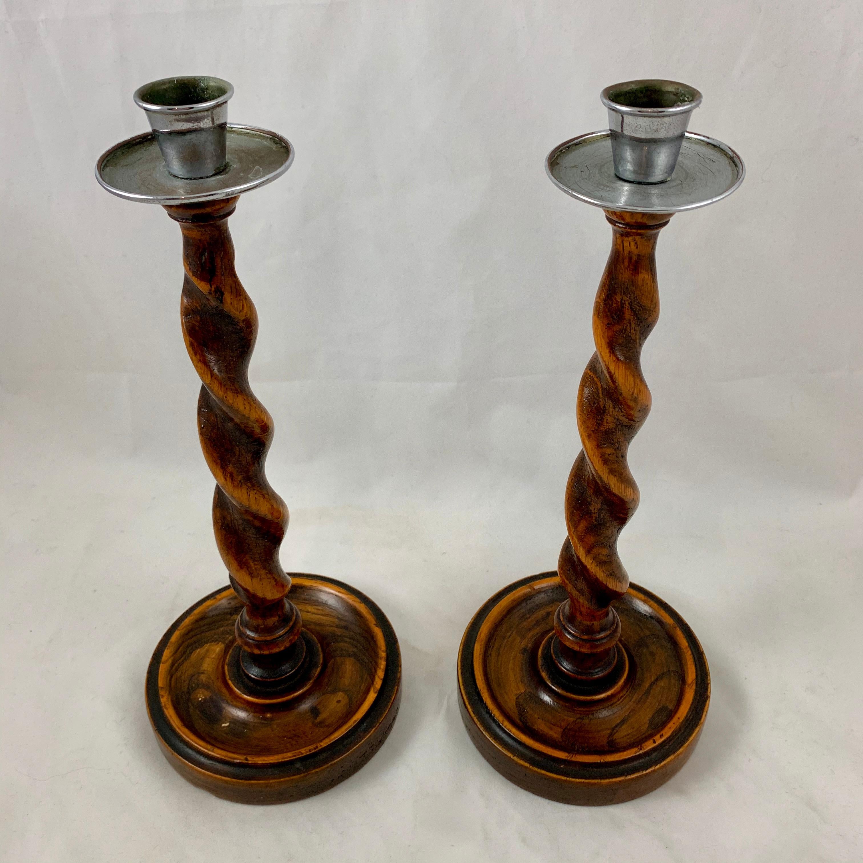 A pair of Barley-Twist oak and pewter topped candlesticks, England, circa 1890-1900.

The Barley-Twist form is based on a twisted stick of barley sugar and was popular in England for making candlesticks and furniture. It is inspired by the