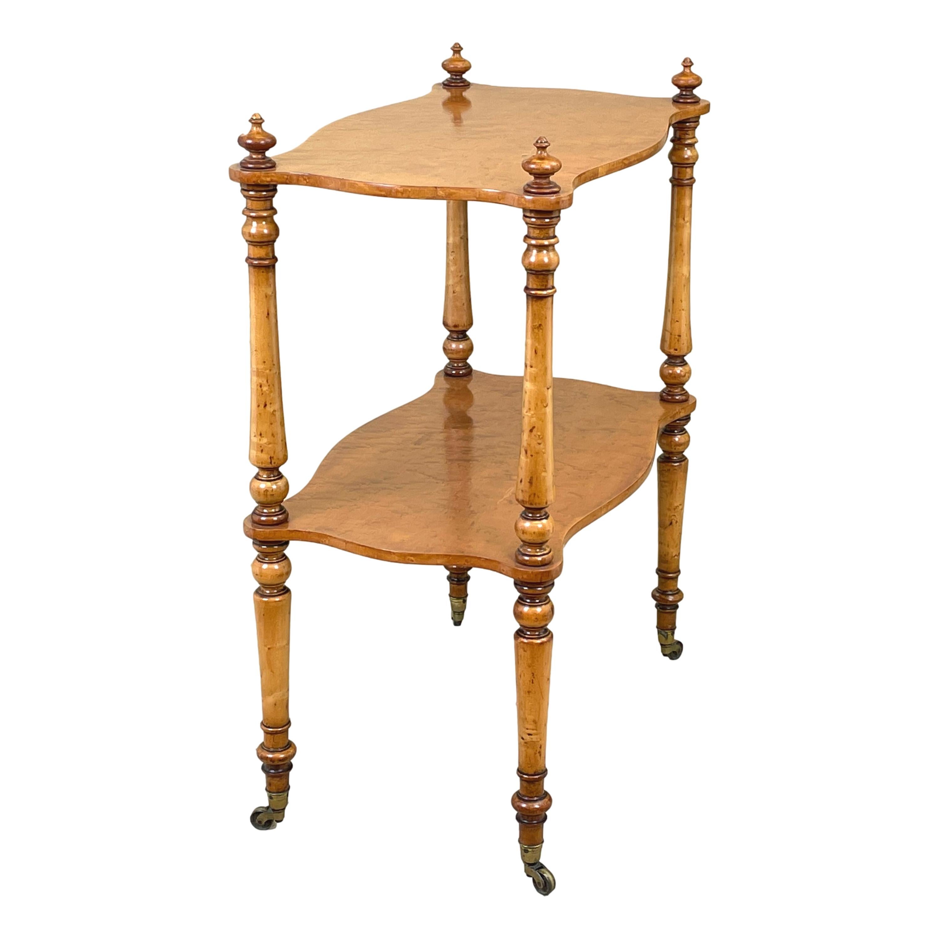 A charming mid 19th century English birds eye
maple wood English étagère, or whatnot, having
two well figured shaped tiers united by elegant
turned upright supports terminating on
original brass castors

(This fabulous quality and useful piece