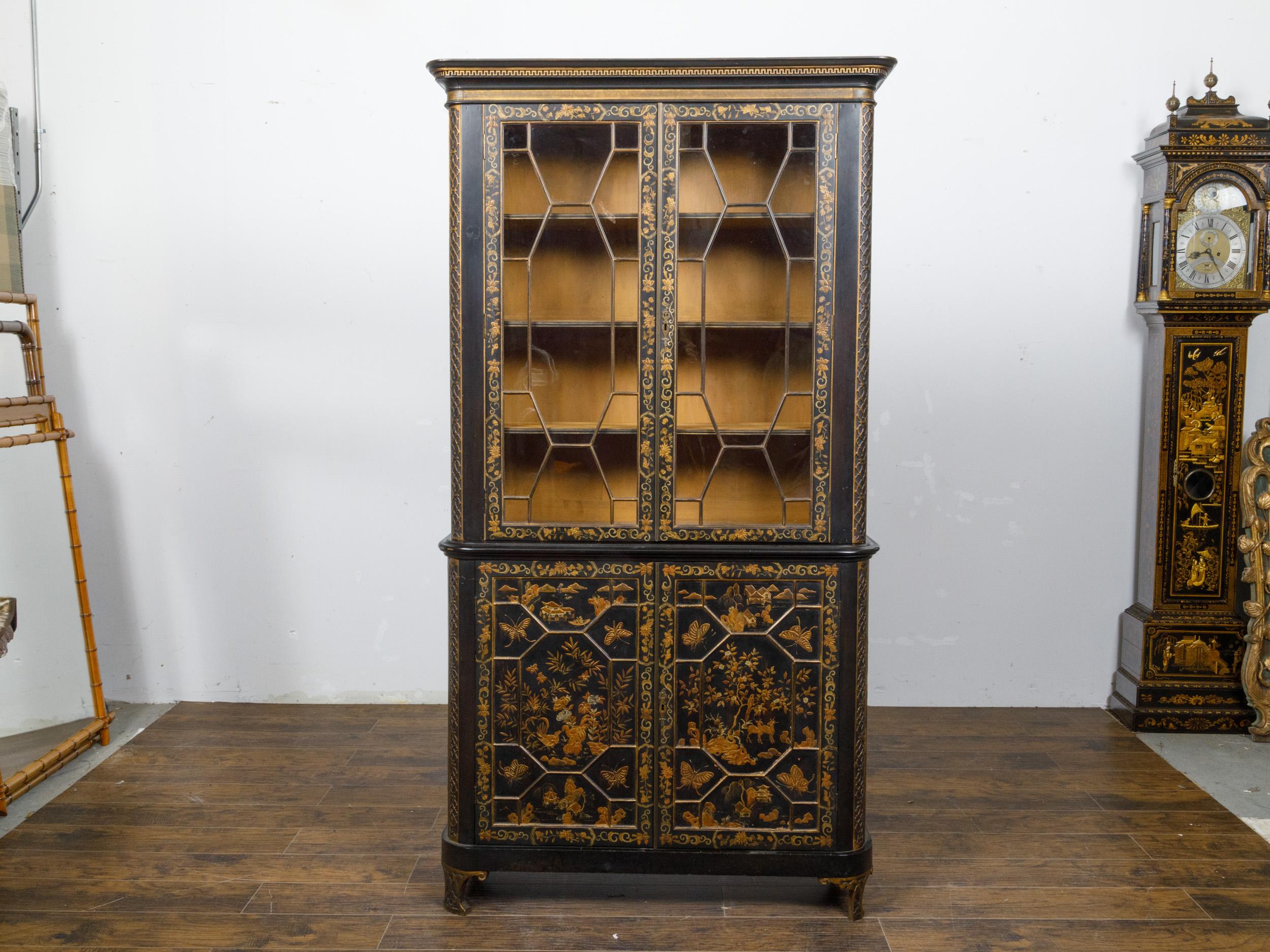 An English black and gold bookcase from the 19th century with Chinoiserie décor and glass doors. This exquisite English black and gold bookcase from the 19th century epitomizes refined elegance and masterful craftsmanship, adorned with intricate