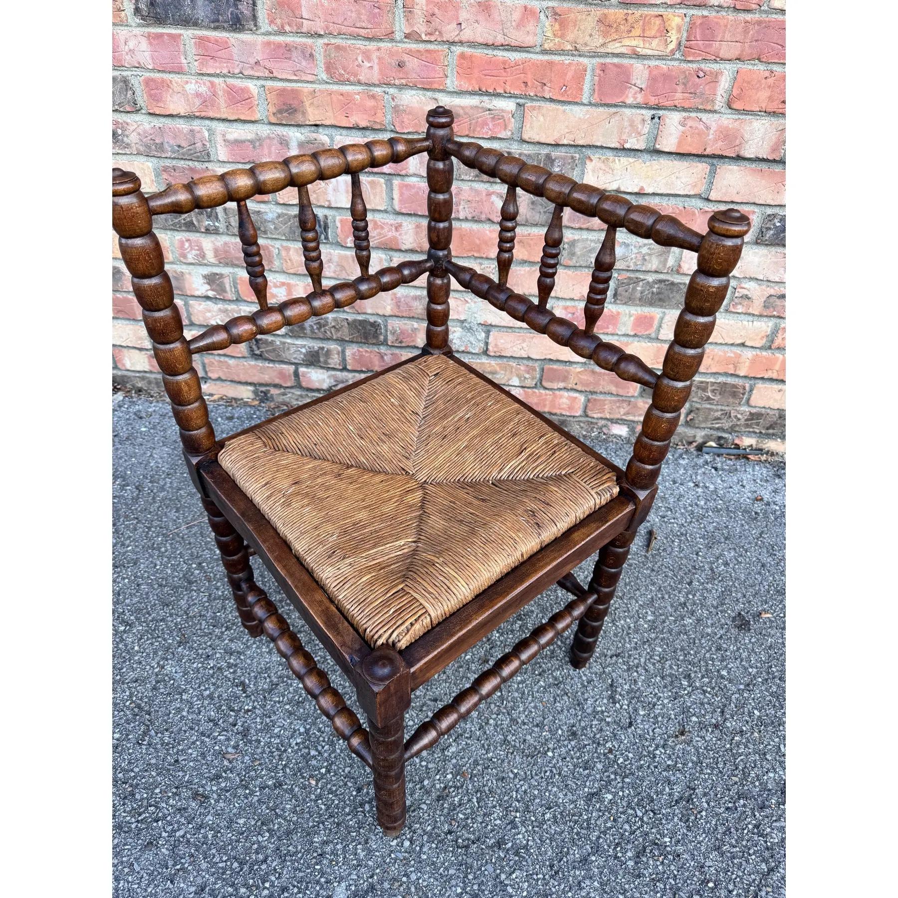 Cette chaise d'angle anglaise du 19e siècle avec assise en jonc est un bel exemple d'assise en situation ! Le dossier et les pieds en bois foncé de style bobine permettent un style classique et l'assise en jonc ajoute une touche textile chaleureuse