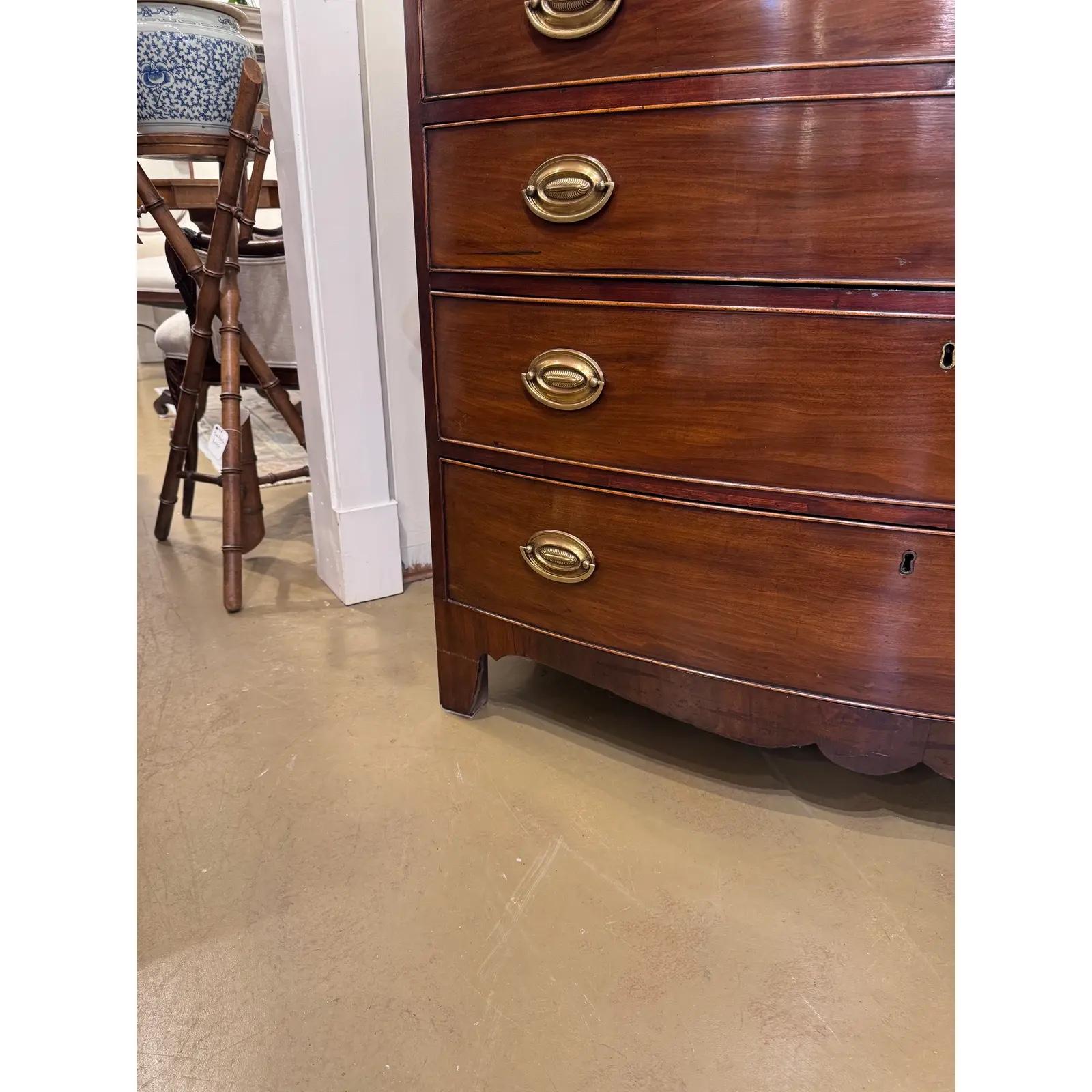 Esta cómoda inglesa con frente de arco del siglo XIX es un mueble de bello diseño, con patas cónicas de buen gusto.Muestra un bonito tono marrón cálido. Presume de excelente artesanía y está fabricado con chapas de caoba y madera maciza de alta