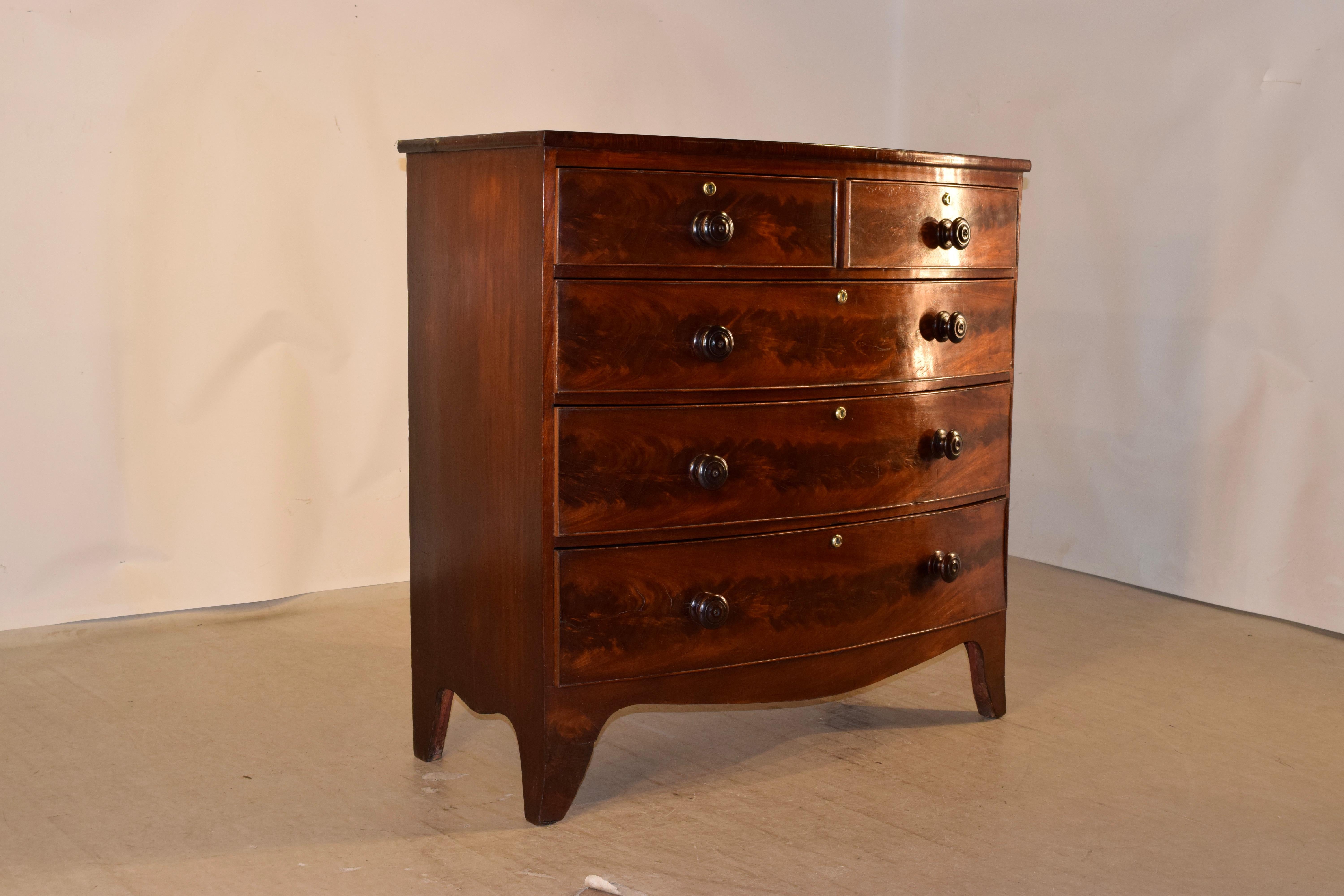 19th century mahogany bow front chest of drawers from England. The chest features a wonderfully grained fiddleback mahogany top, along with fiddleback grained drawer fronts, which are most desirable. The chest has simple sides and two over three