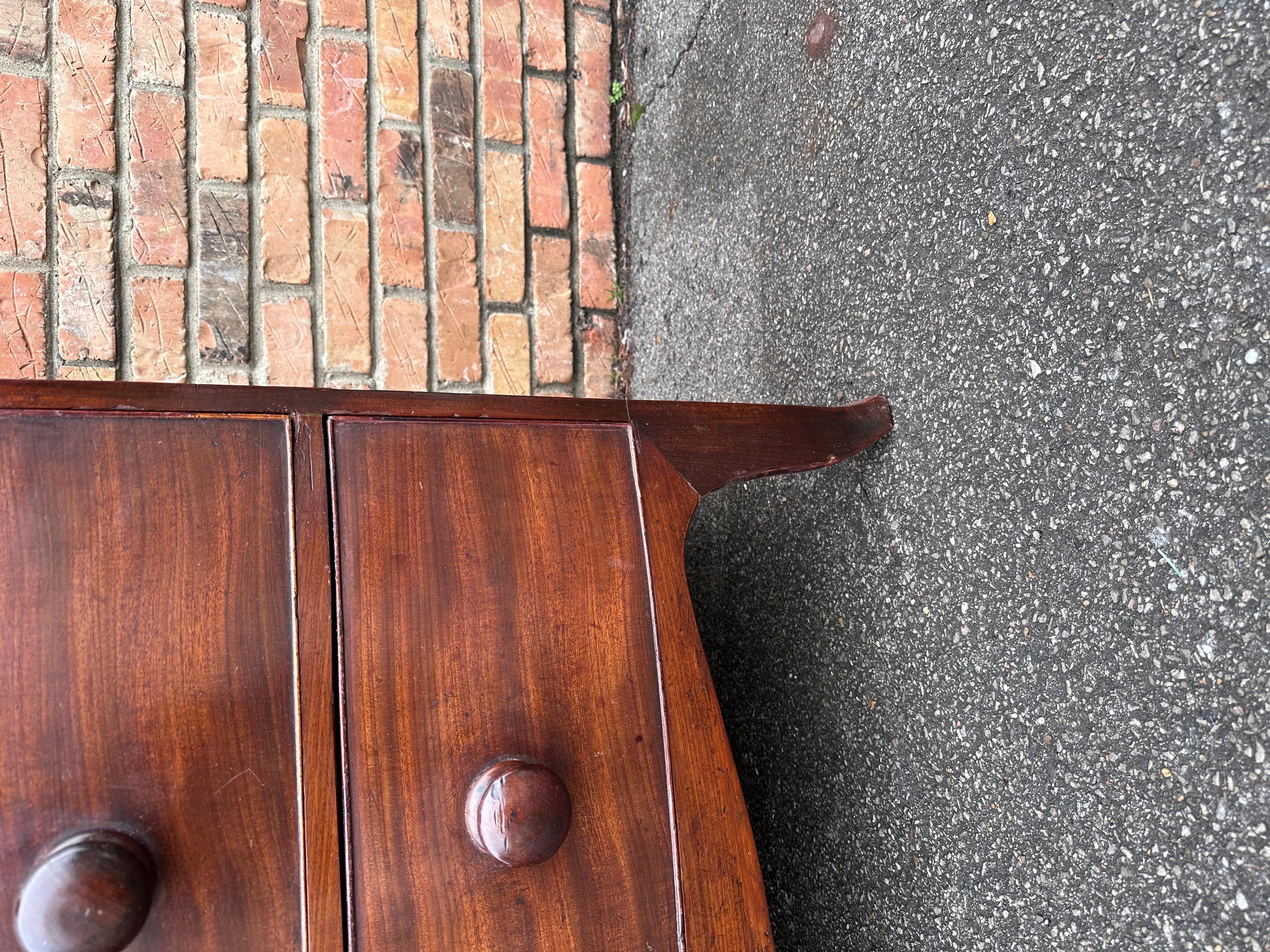 This is a beautiful mid 19th century English Bowfront, chest with original pulls in the traditional darker tone. Two small drawers over three larger one that all slide perfectly. The wood is a flamed mahogany more of a brown tone than a red like