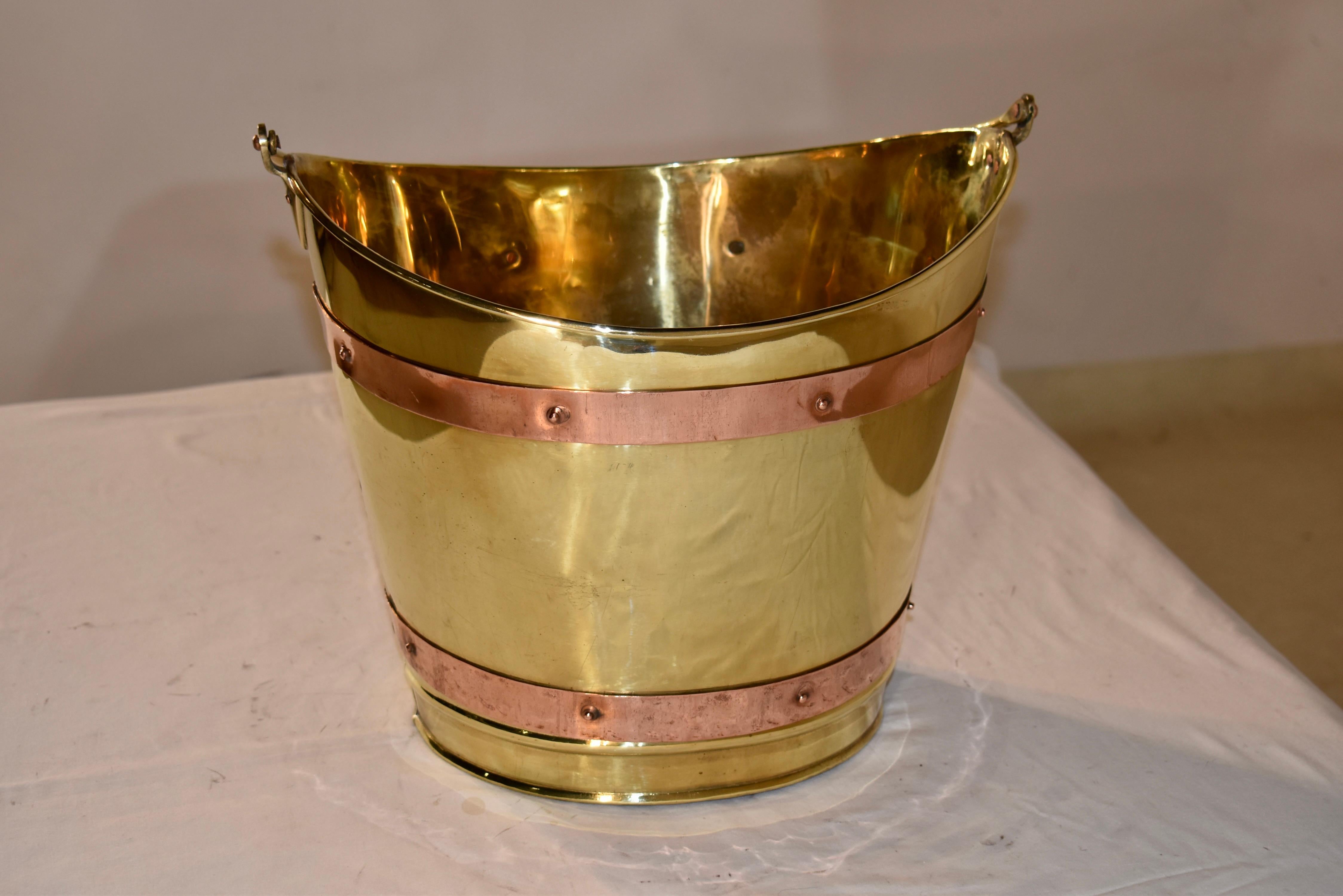 19th century brass peat or oyster bucket strapped in copper.  This is a gorgeous bucket!  The contrast of the mixed metals is stunning and gives the bucket a certain elevation to its design.  The handle when lifted up stands at  19 inches in height.