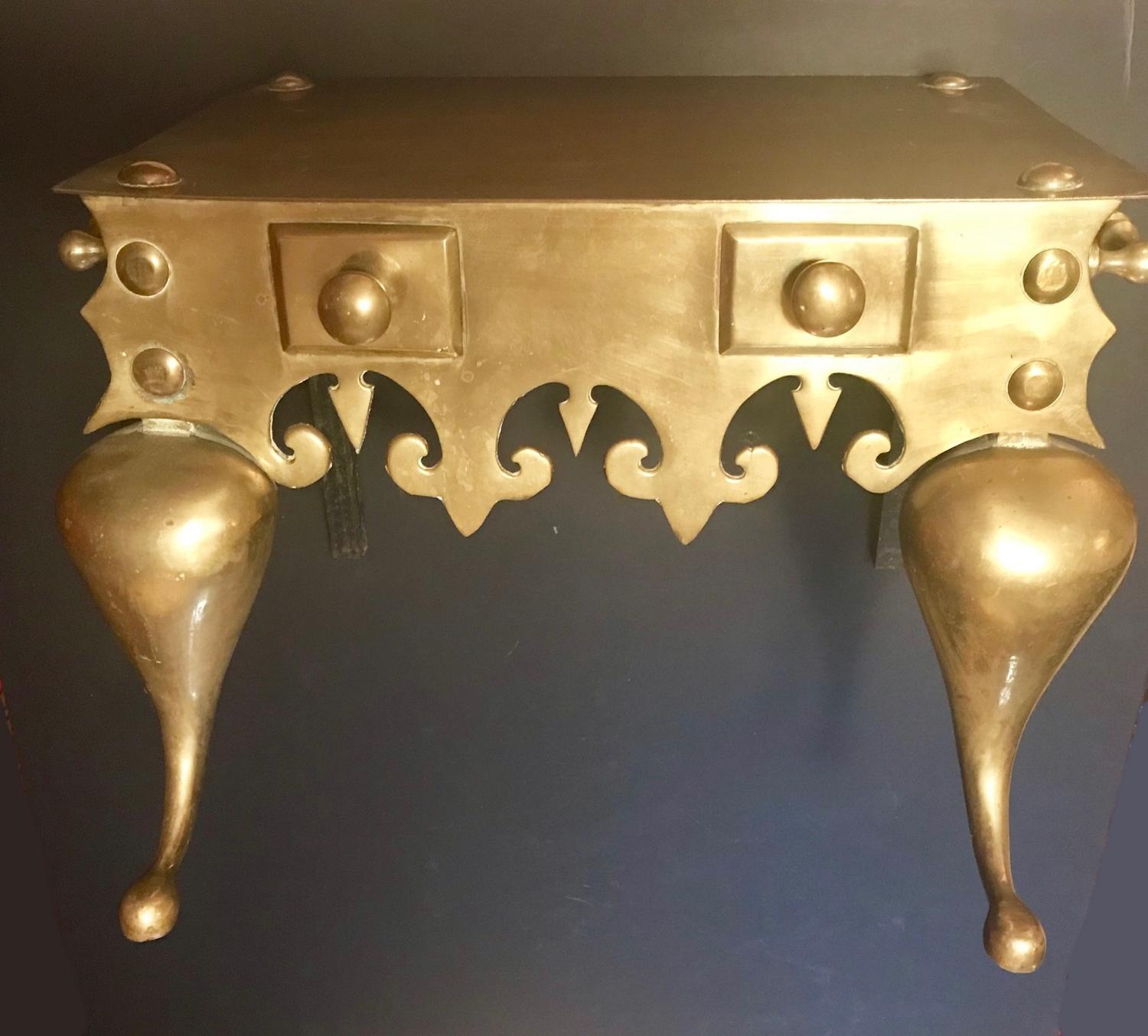 This large brass footman features a shaped frieze with decorative knob fixtures and handles on each side. The stand is raised on cabriole front legs.

Measurements: W 19” x D 12” x H 12”
Condition: Good. Wear consistent with age and use.
 