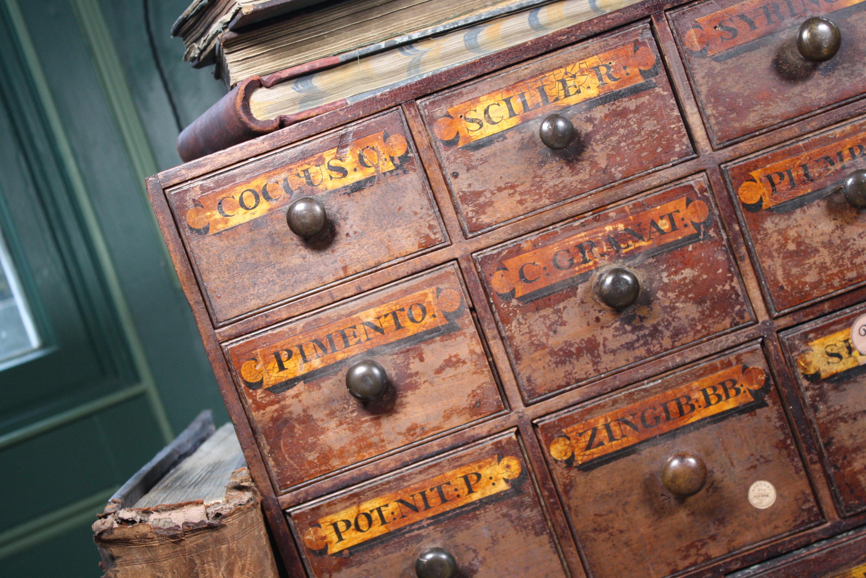 A good run of original chemist drawers, third quarter of the 19th century in age, English in origin.

These originally where housed at A. Johnson Dyer Chemist Acre Lane Brixton London. With hardwood draw front, decorative moulding and a pine