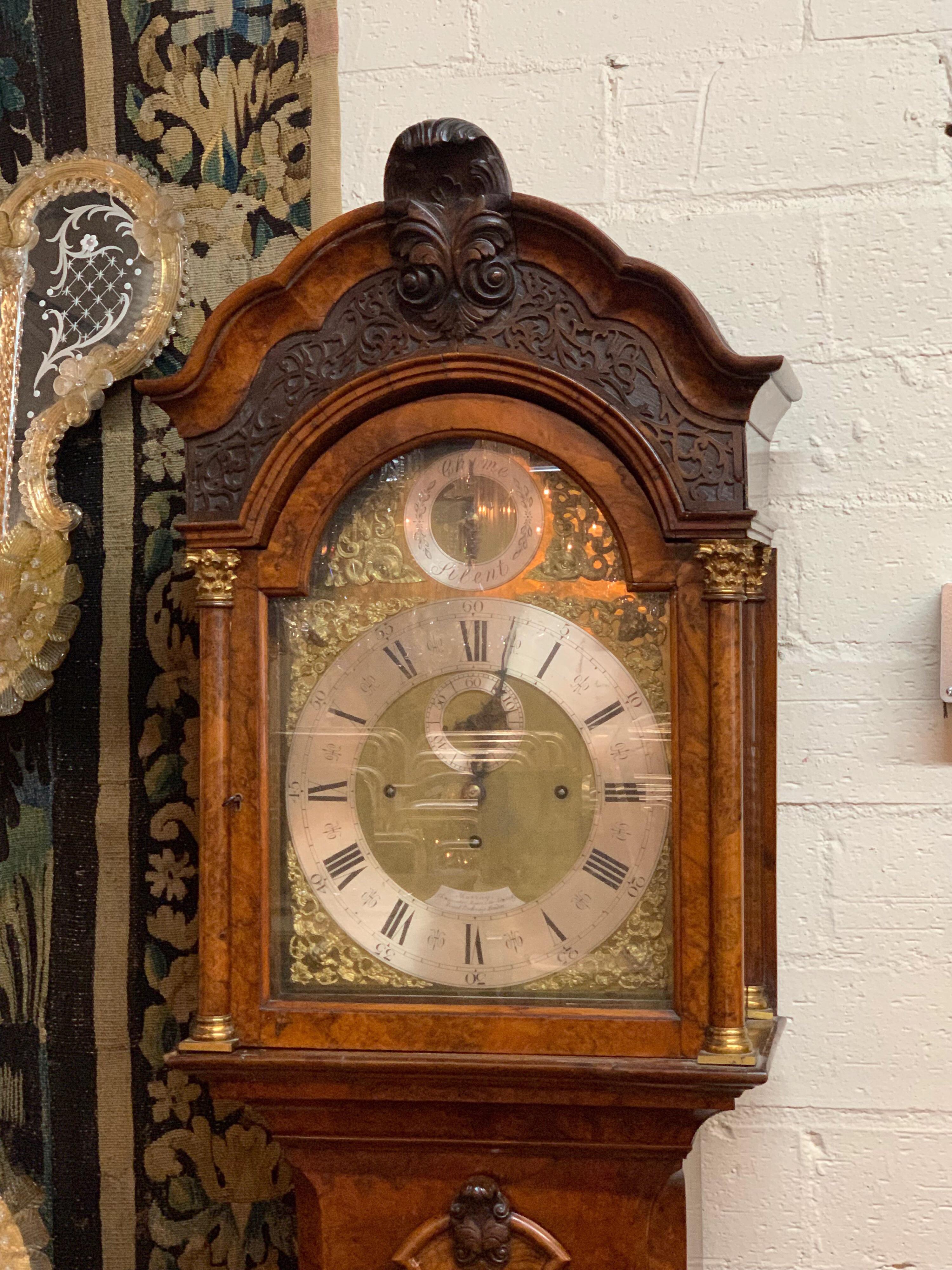 Handsome 19th century English burl walnut inlaid grandfather clock with important movement by Murray, London. This clock has inlays of burl wood and wood carvings at the top and sides of the clock. The face of the clock has beautiful gilt brass