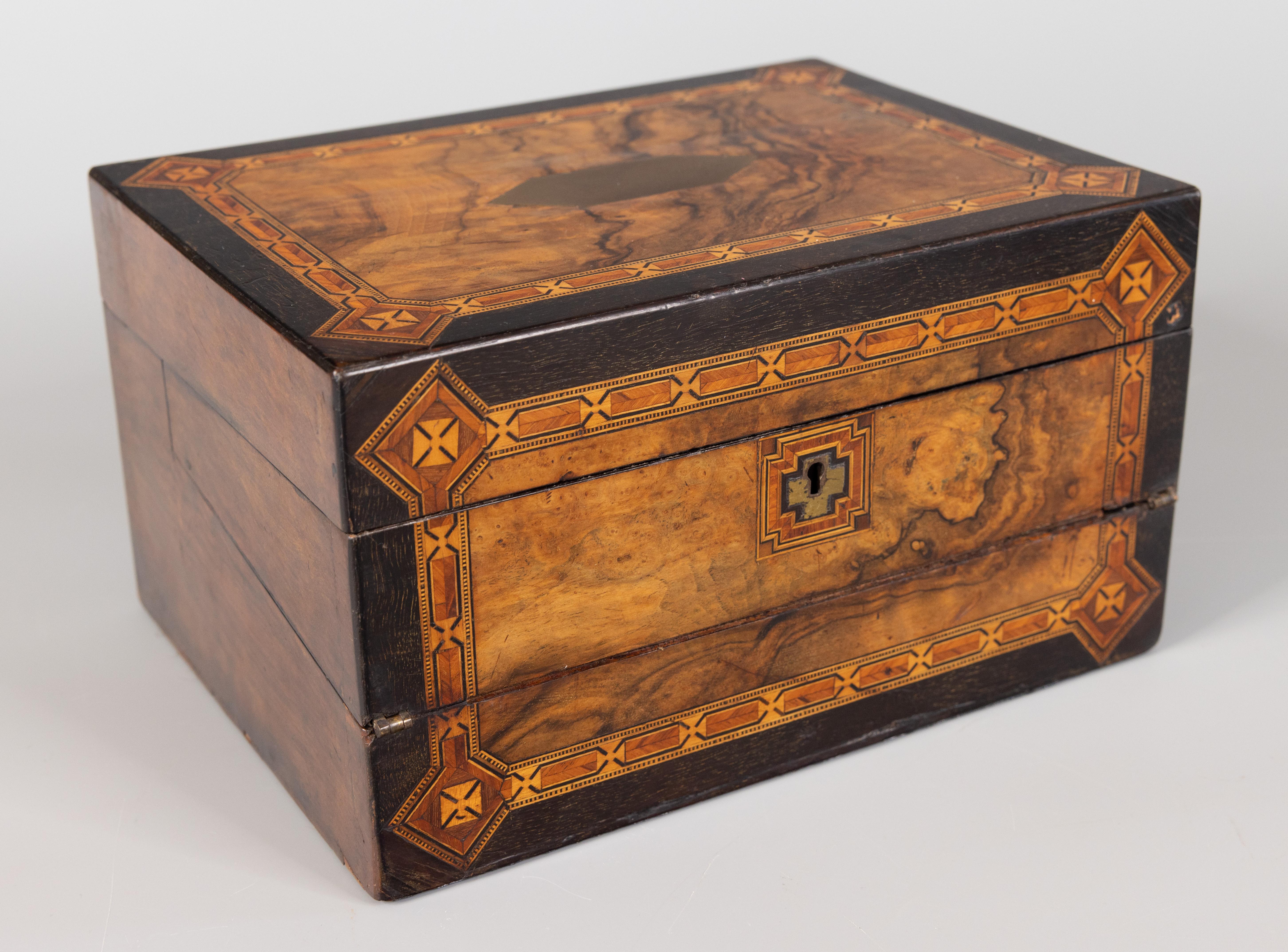 A superb antique English burl walnut and ebony inlaid tunbridge writing slope box / lap desk, circa 1870. This handsome box opens to reveal a leather writing surface, pen tray compartment, and the original glass inkwells. The writing surface opens
