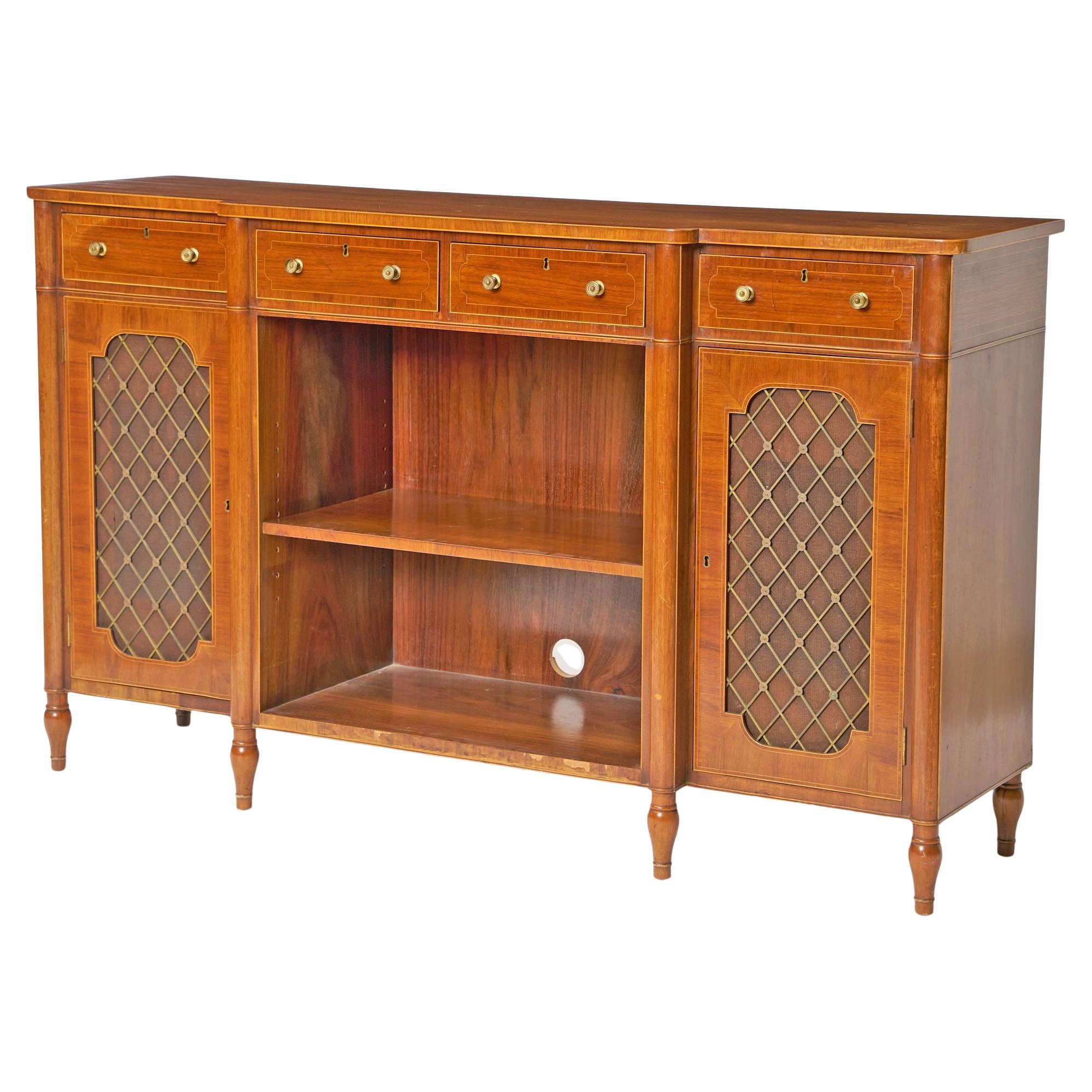 Este distinguido aparador inglés de estilo Regencia de mediados del siglo XIX, fabricado en madera de caoba con detalles incrustados, es un ejemplo magistral de diseño y elegancia de época. Con cuatro cajones superiores con herrajes clásicos de