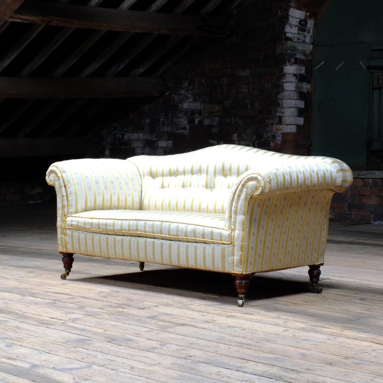 A superb quality antique Country house sofa raised on 4 nicely turned legs with original brass castors. The silk upholstery is I believe to be original and not without its flaws with some historic water marks and a small tear at the back which does