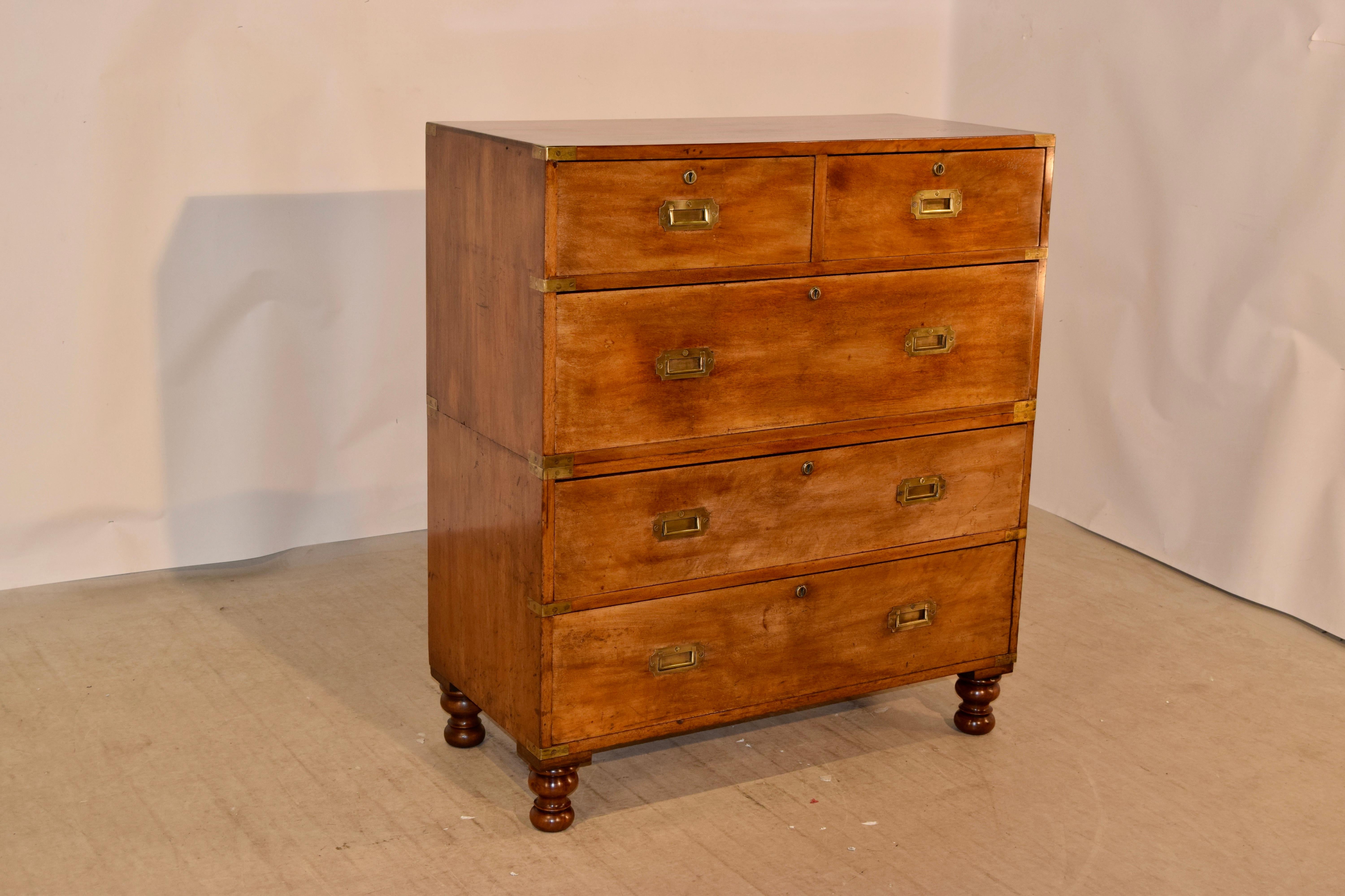 19th century campaign chest from England made from camphor wood. The corners and sides of the chest are banded with hand cast brass caps, which complement the hand cast brass handles and escutcheons. The case is simple in its elegance and is raised