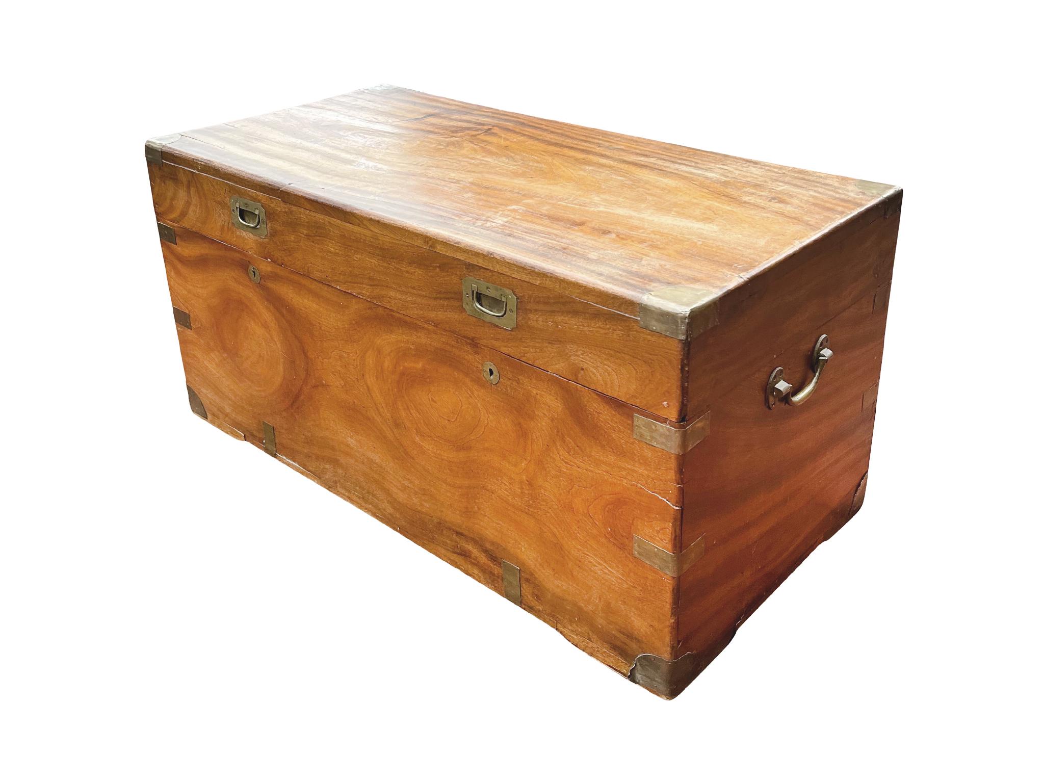 Hand-crafted in England in the 19th Century, the camphorwood chest is brass-bound on the corners and edges, with bail handles mounted to the sides and with two brass inset pulls and locks. Accrued marks over the years give the chest warmth,
