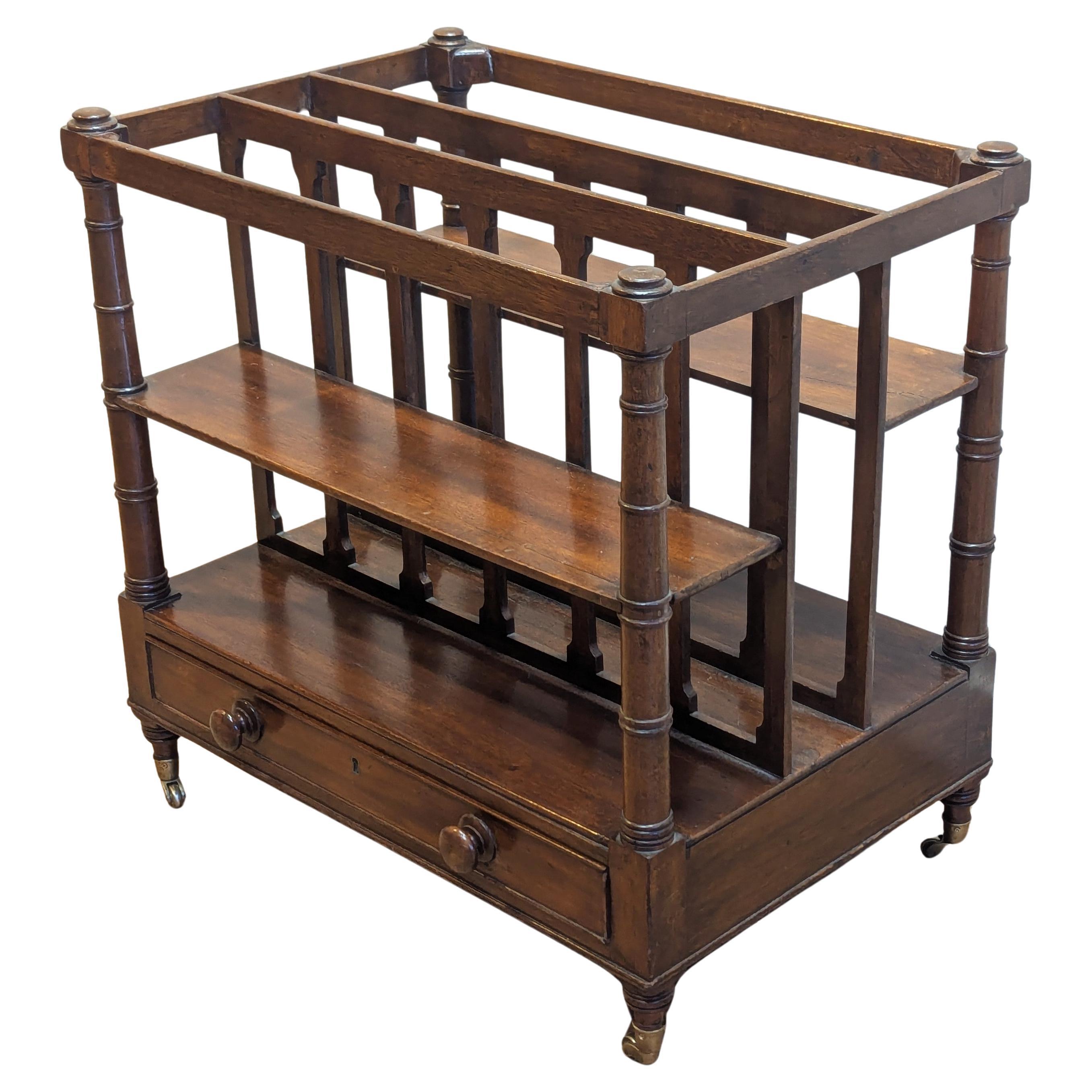 Revistero inglés del siglo XIX.  Muy bonito Canterbury antiguo sobre ruedas de latón con cuatro estantes y una gran manga central con un cajón inferior.  Maravillosas patas cónicas torneadas con diseño de jaula ranurada de caoba.  Funciona bien como