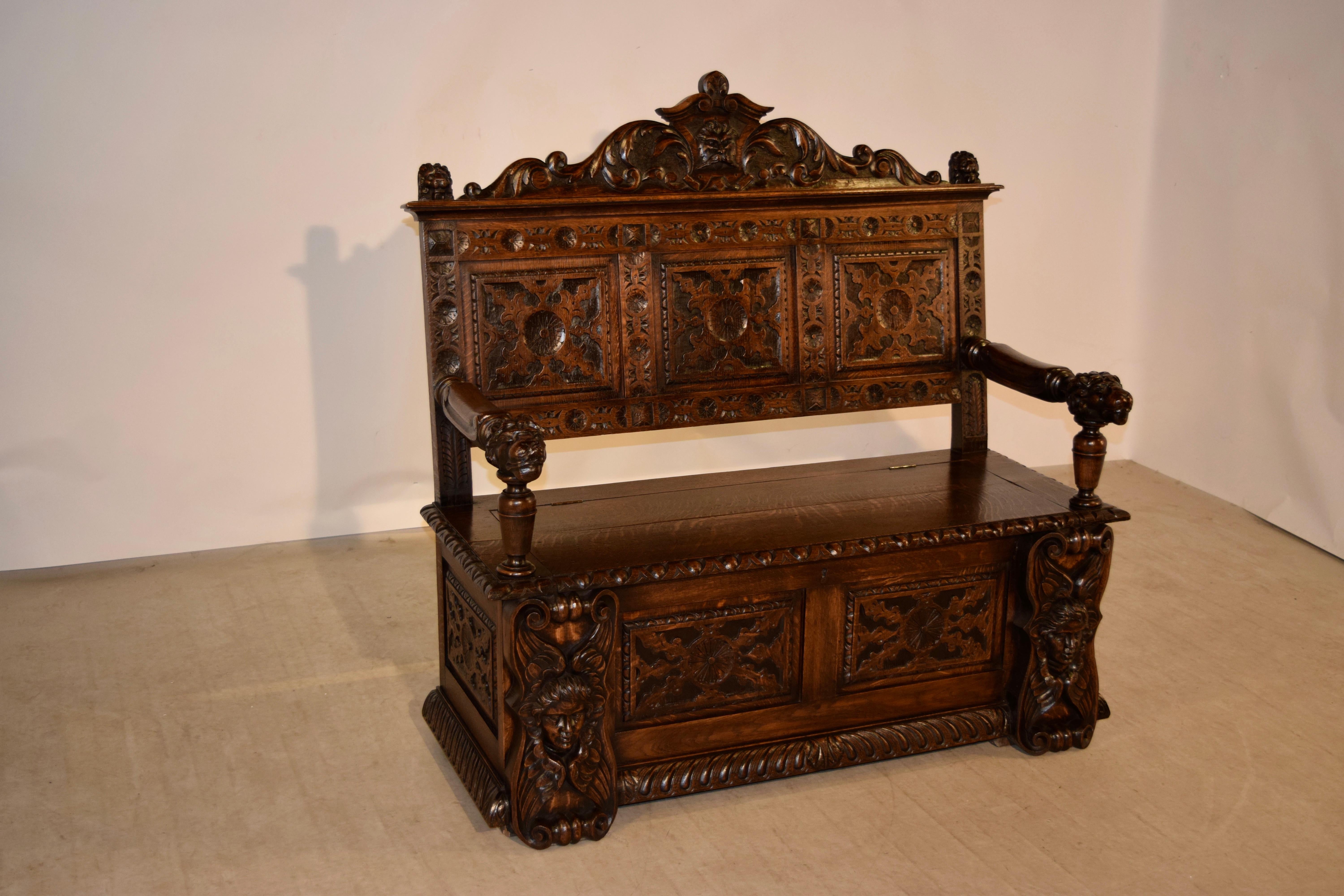 19th century bench from England with a wonderfully hand-carved three-panel back, adorned with a lovely shaped crown, following down to paneled sides and front, which are also hand-carved and are flanked by wonderfully carved angels. This piece has a