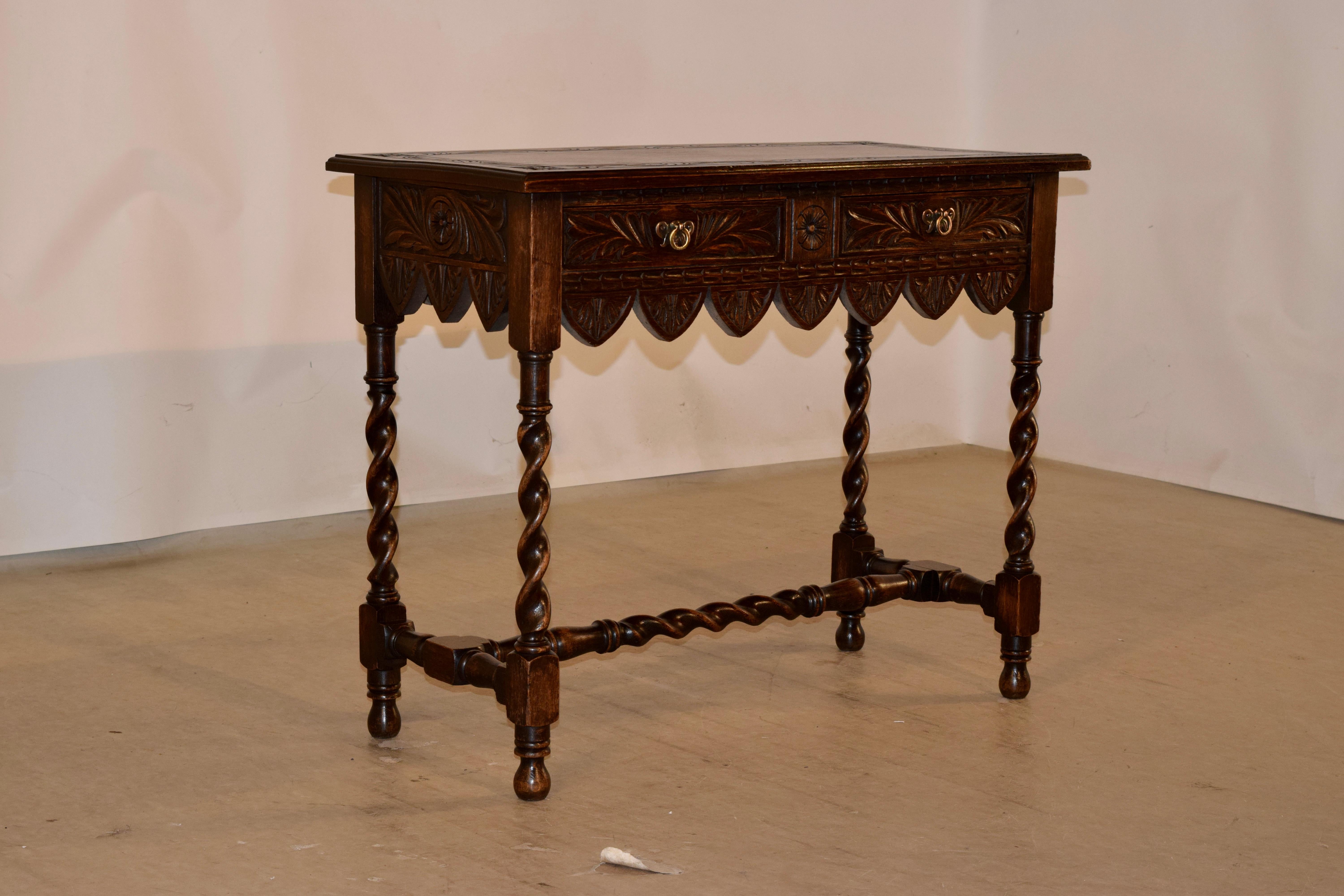 19th century oak console table from England with a beveled edge around the top and a central carved band with acanthus leaf decoration. The apron is hand carved decorated on all four sides for easy placement in any room, and terminates in a