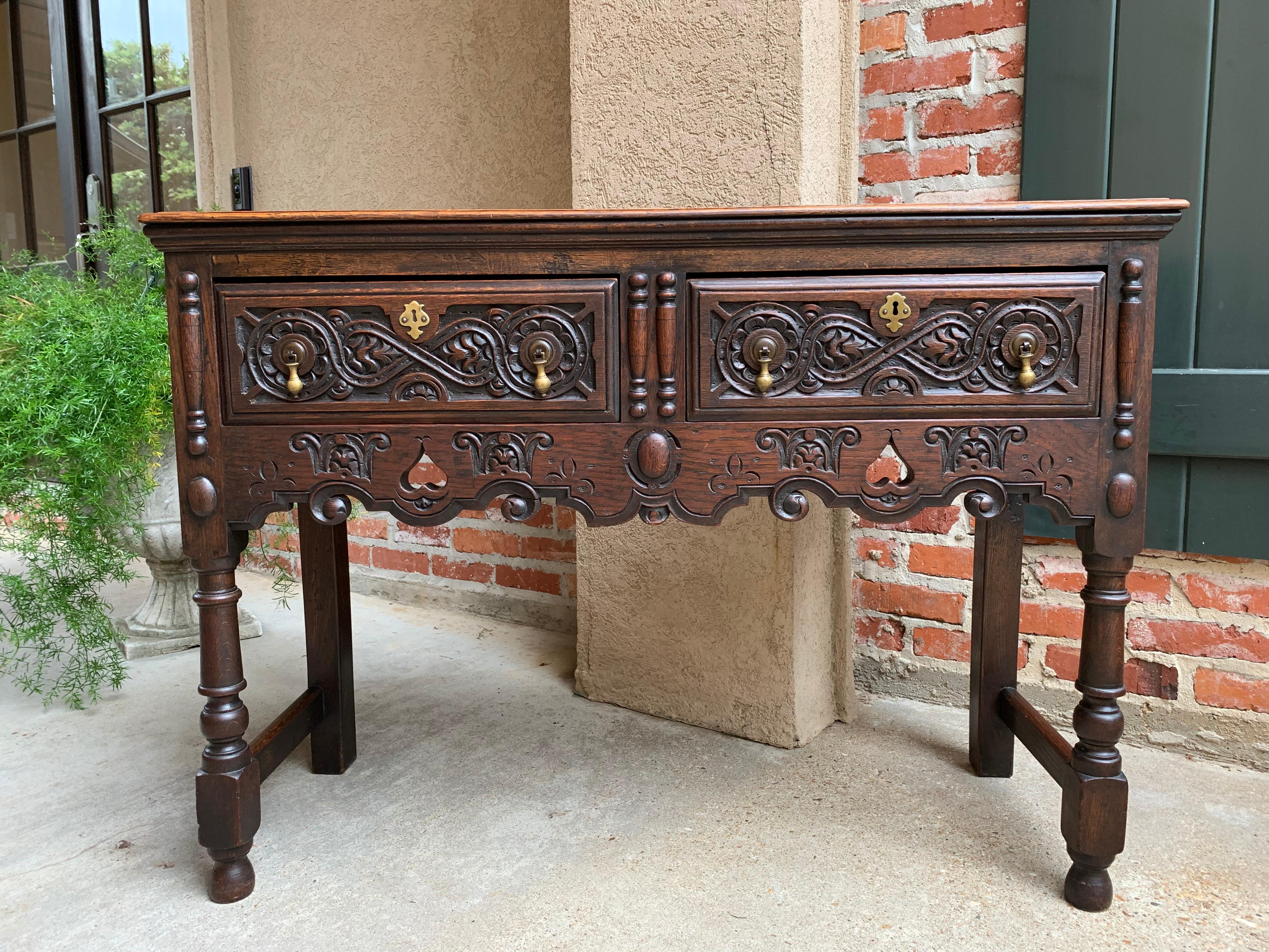 Direct from England, a gorgeous and versatile antique English carved oak sofa table!
~ Heavily carved panel fronts on both drawers
~ Elaborate carved details and open carvings on the wide front apron with scalloped lower edges
~ Large applied