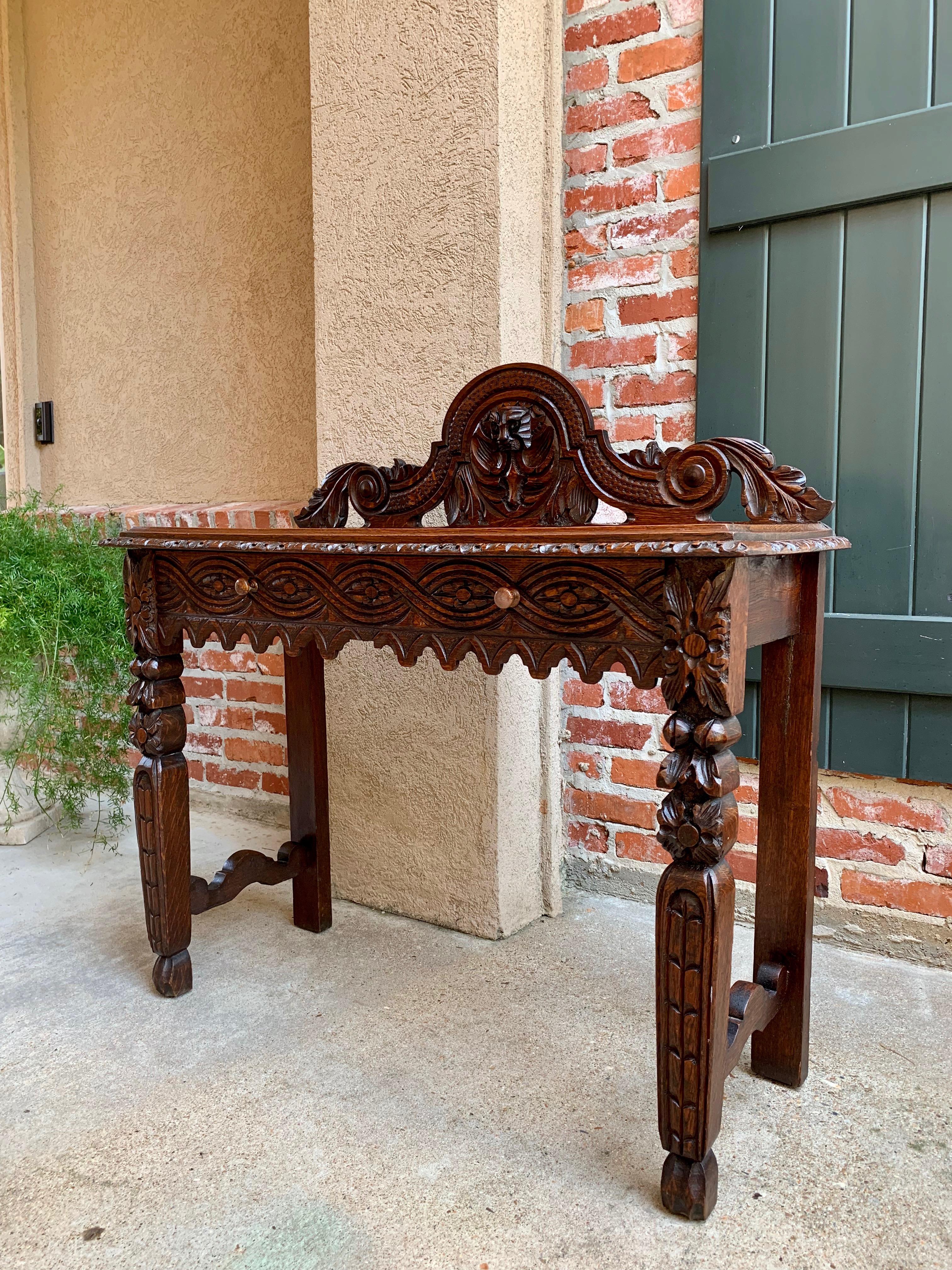 Direct from England, another wonderful antique English hall table or sideboard with gorgeous hand carvings throughout!
~ Large dimensional carved back crown piece with center medallion flanked by large scrolls on either side
~ Wide front apron