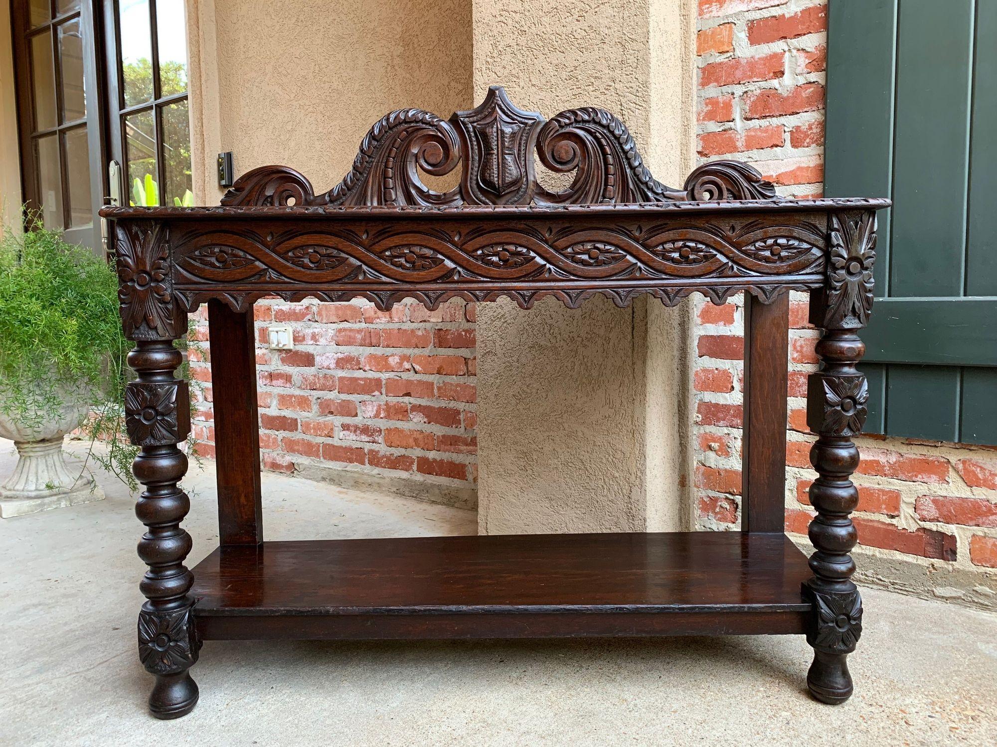 Direct from England, a stunning antique English hall table or sideboard with gorgeous hand carvings throughout!~
~Huge dimensional carved back crown piece with center shield medallion flanked by large scrolls on either side~
~Wide front apron has