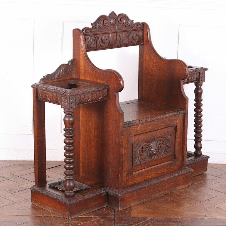 Highly carved English Victorian oak hall bench with storage under the lift-up seat and umbrella/stick stands to each side. Bobbin-turned column supports and carved 'Green Man' face to front. C.1890


 