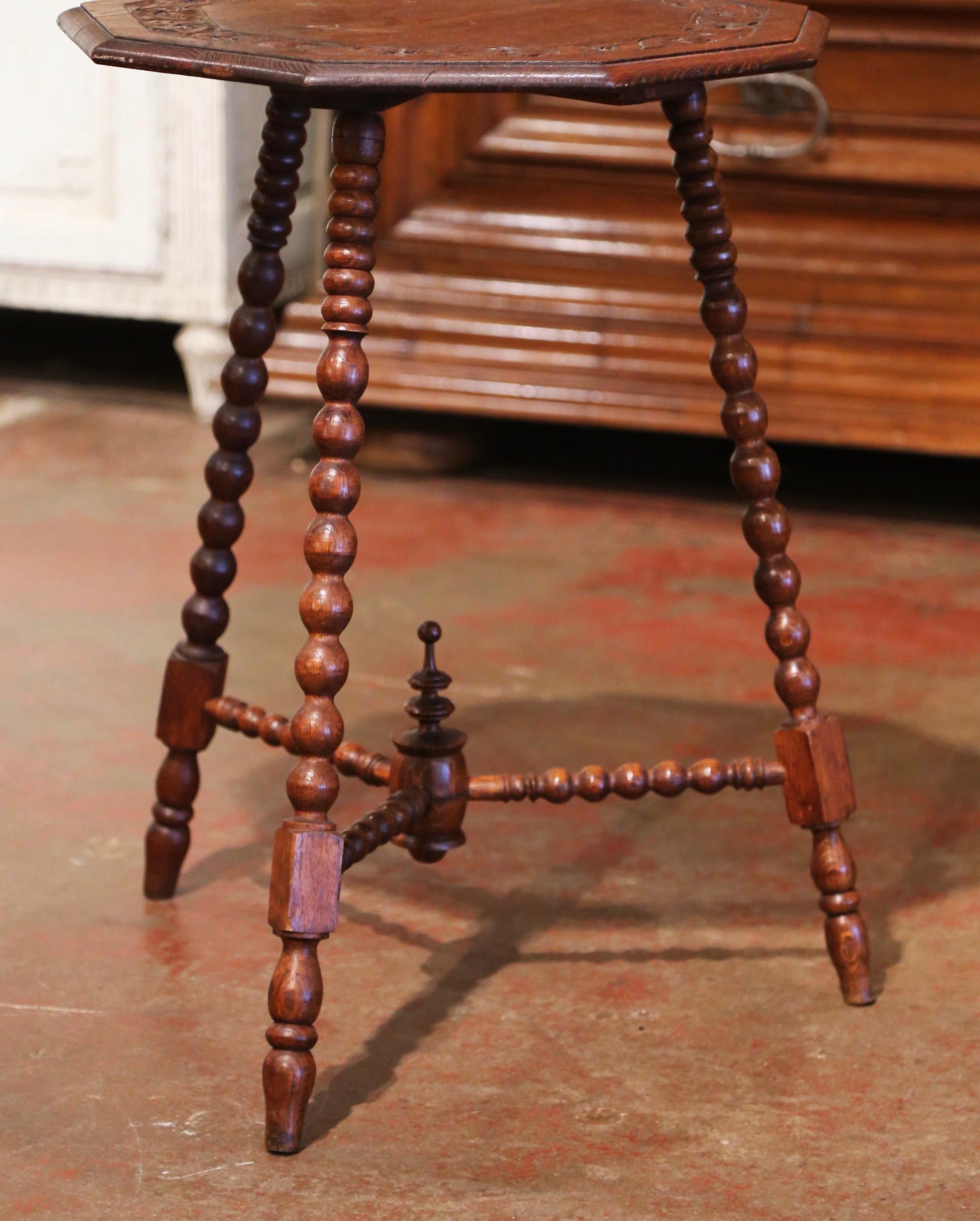 Decorate a den or living room with this antique cricket table. Crafted in England circa 1880 and built of oak, the side table stands on three turned legs decorated with a bottom stretcher embellished with a central finial. The polygon top is