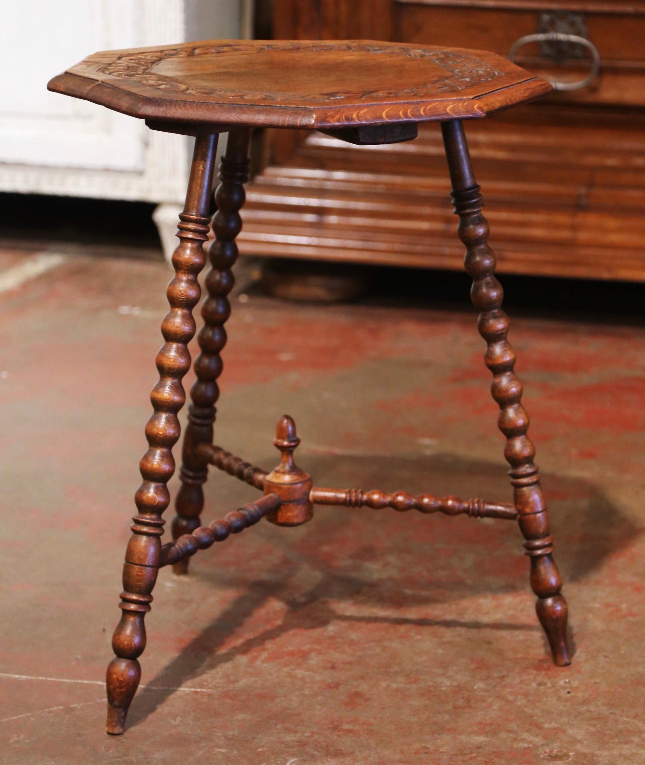 Decorate a den or living room with this antique cricket table. Crafted in England circa 1880 and built of oak, the side table stands on three turned legs decorated with a bottom stretcher embellished with a central finial. The polygon top is