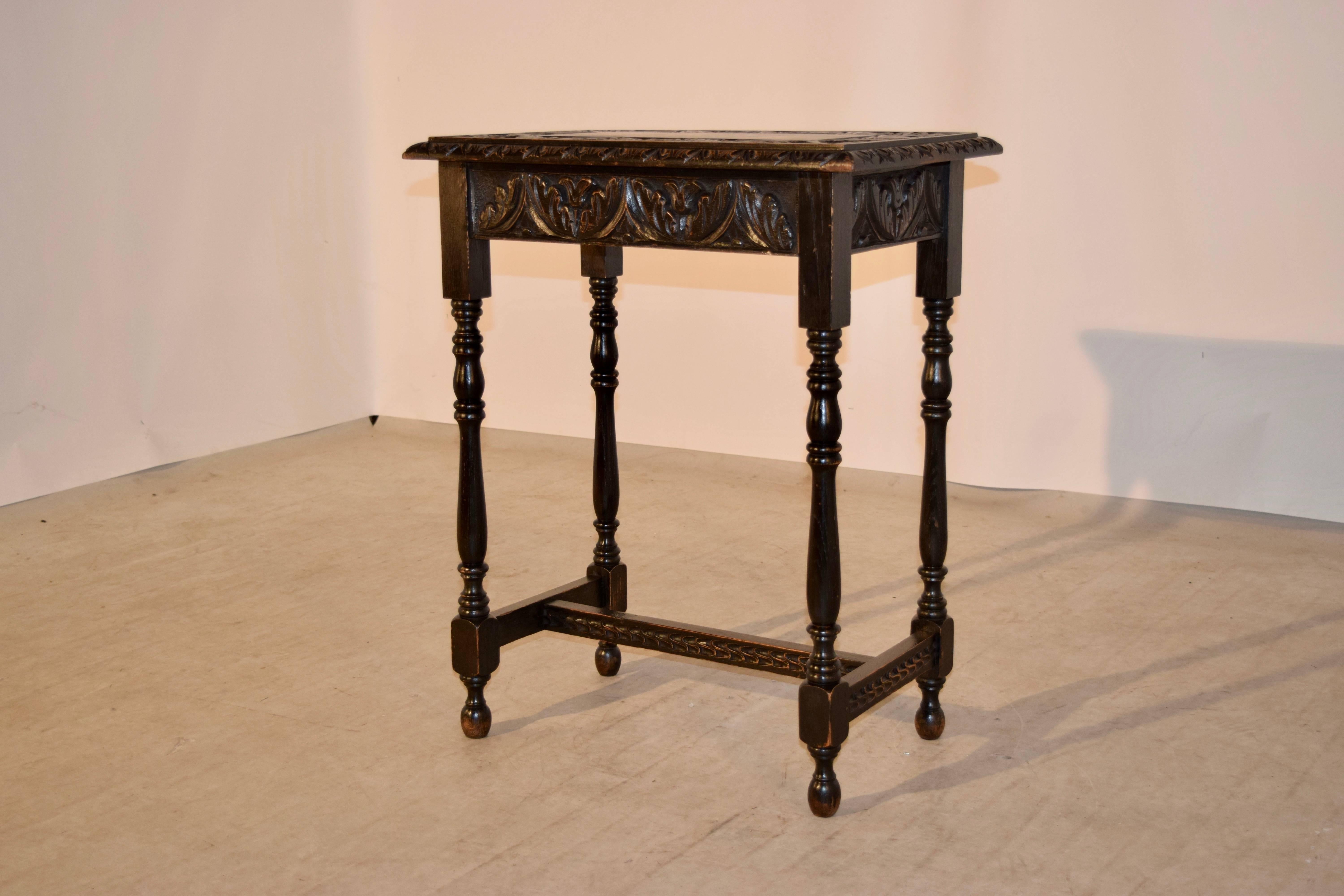 19th century hand-carved oak side table from England. The top is banded with hand-carved designs and has a bevelled and gadrooned molded edge, following down to a hand-carved apron. The legs are hand-turned and are joined by cross stretchers, which